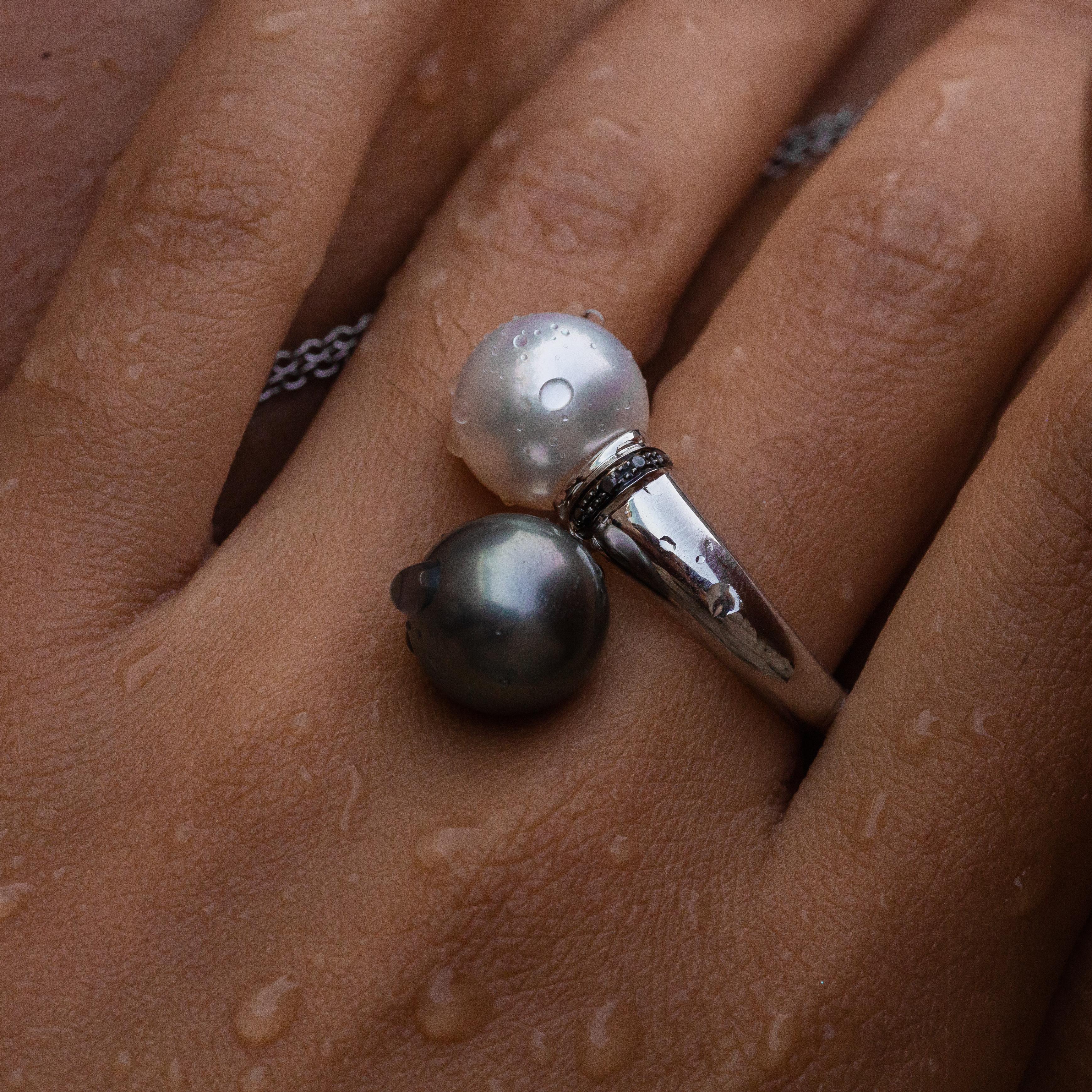 18K white gold pearl ring is from Sirène Collection. This elegant ring is created with 2 South Sea white and black pearls in total of 22 Carat and natural colourless and black diamonds in total of 0.05 Carat. White pearl has size 11.51 x 11.49 x