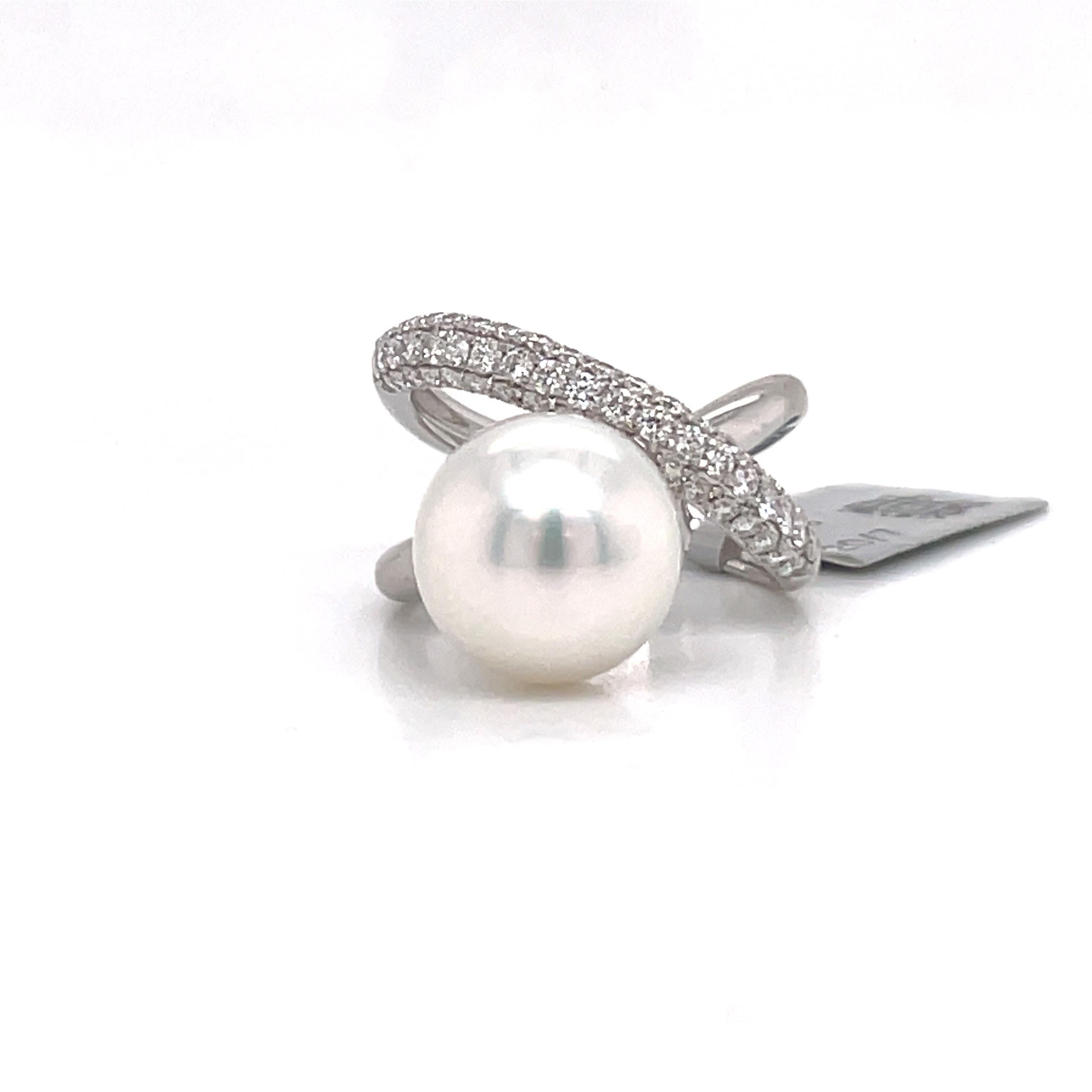 18 Karat White gold fashion X design ring featuring one white South Sea Pearl measuring 11-12 MM flanked with 53 round brilliants weighing 0.76 carats.
Color G-H
Clarity SI