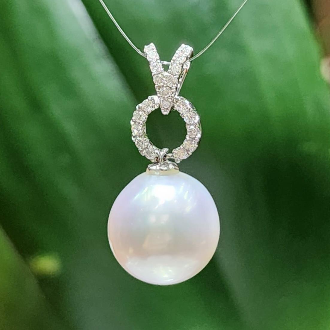 The 18K White Gold South Sea Pearl and Diamond Pendant is a stunning piece of jewelry that exudes sophistication and luxury. Its centerpiece is a beautiful 13 mm South Sea pearl, known for its lustrous glow and captivating charm.

The pearl is
