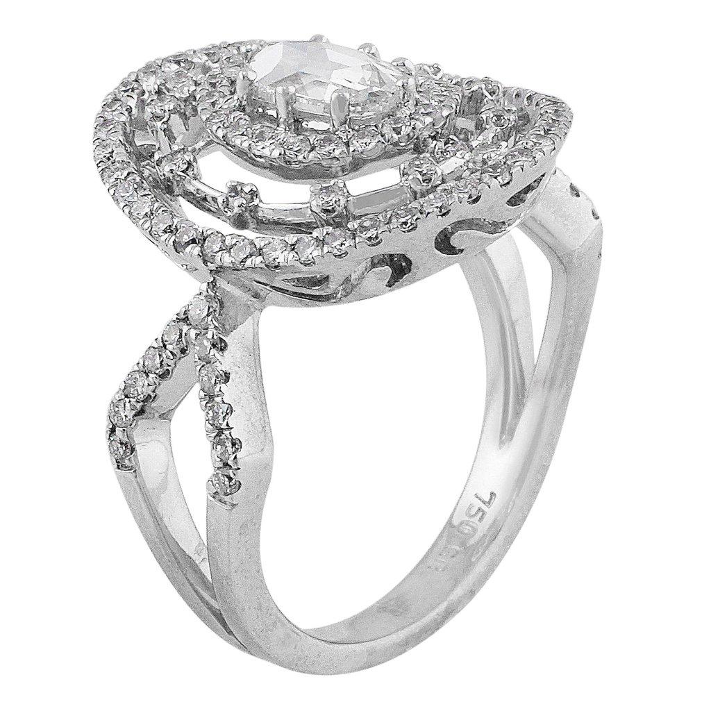 A stunning estate ring of 18k white gold set with a center almost colorless oval princess cut diamond, weighing approximately 0.8cts and of VS clarity, surrounded by round brilliant cut diamonds. The ring contains 96 round brilliant diamonds,