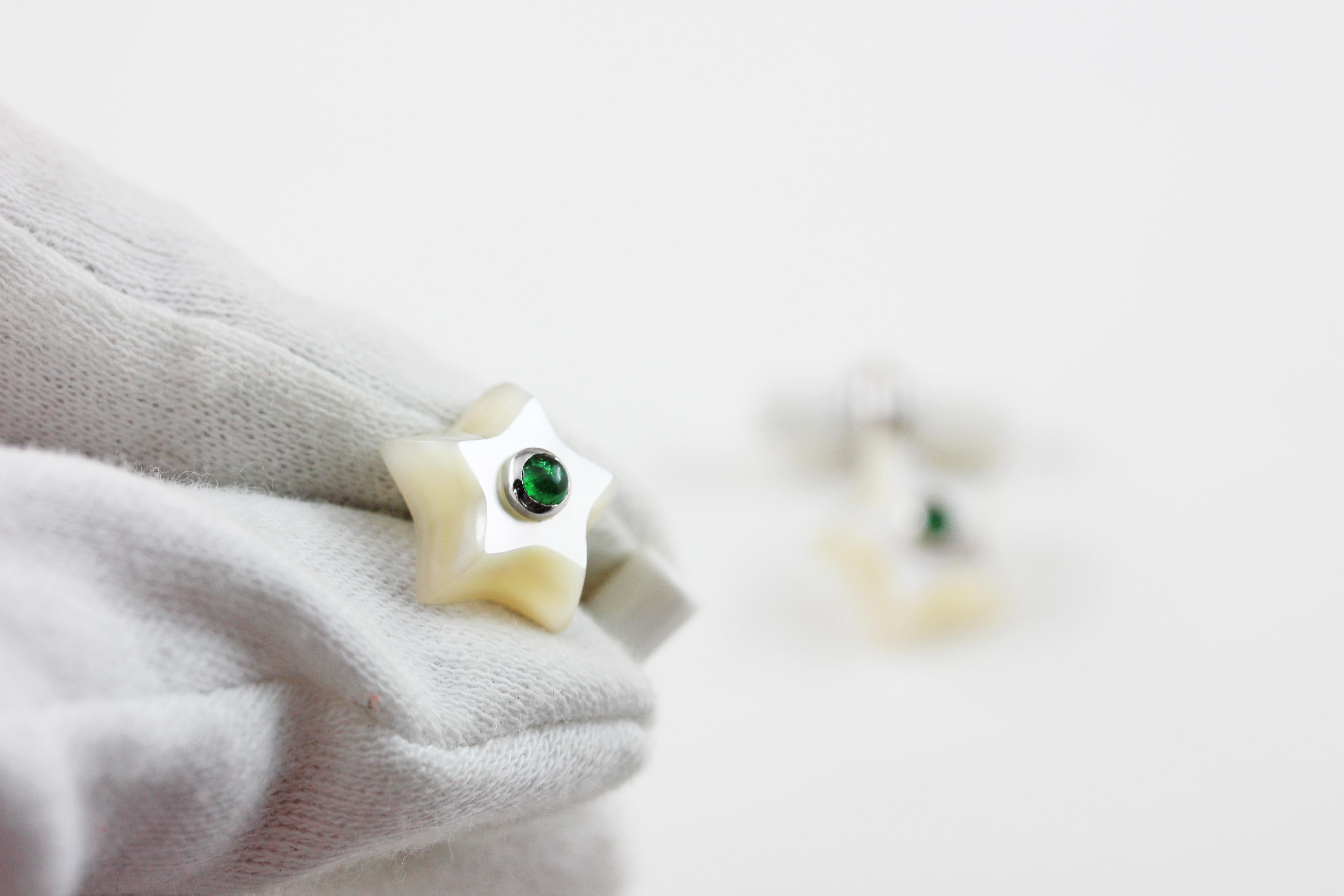 This charming pair of cufflinks is entirely made in mother of pearl, hand carved as stars and adorned in the center with cabochon emerald. 
The 18 karat white gold post links this element to the toggle, which is a simple cylinder.

Dimensions: 
    
