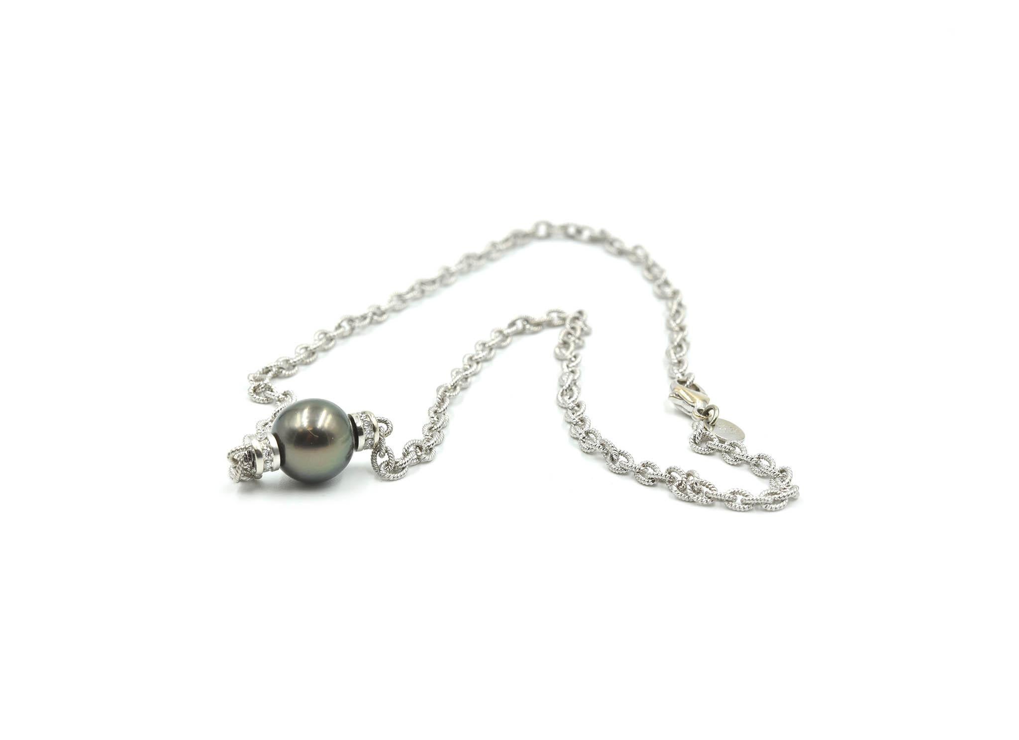 This modern necklace is made in 18k white gold. There is an 11mm Tahitian pearl at the center, which is accented by round diamonds (0.18cttw). The necklace measures 17 inches in length, and it weighs 17.86 grams. 