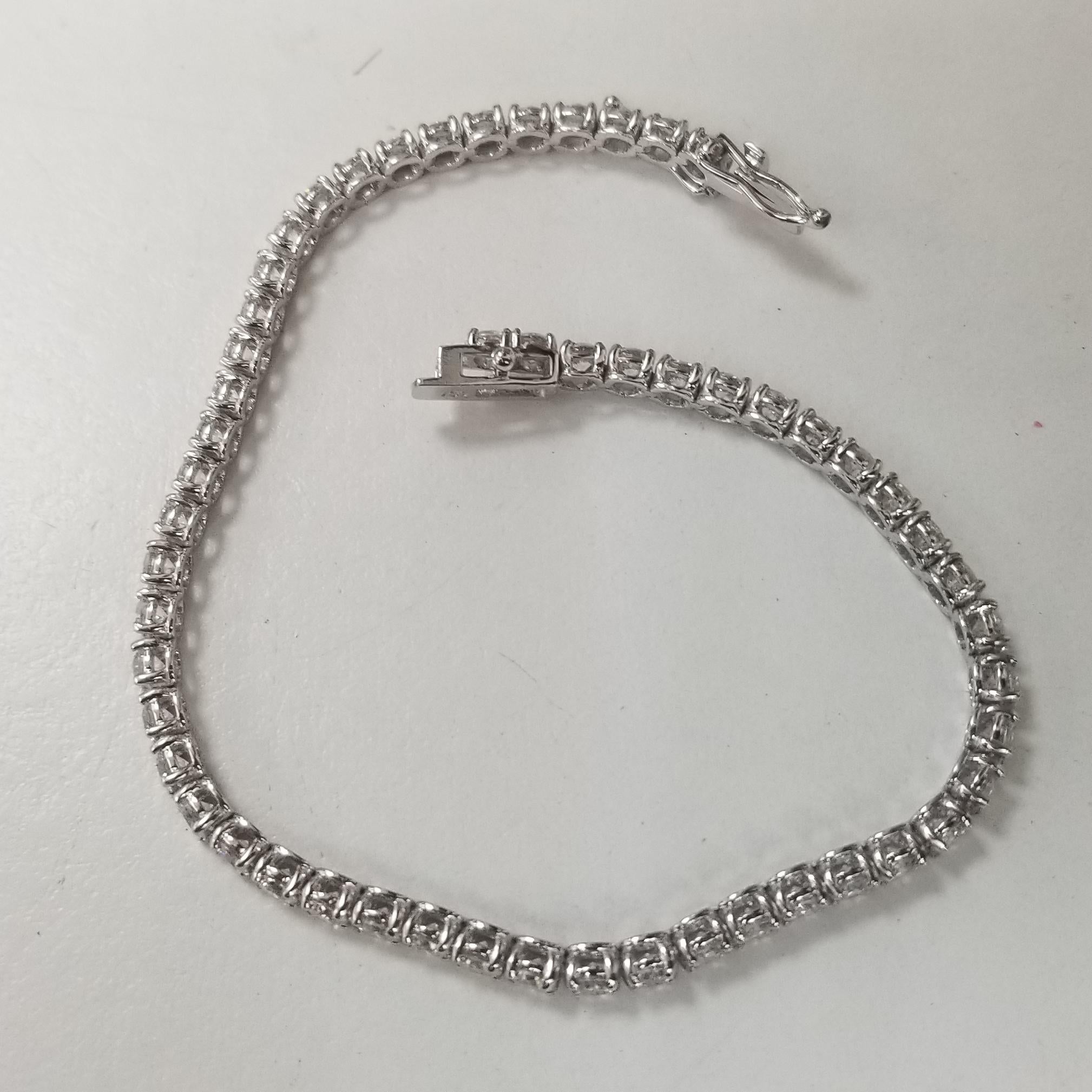 This is very beautiful 18k white gold custom made tennis bracelet with 55 round diamonds color F-G and clarity VS2-SI1 weighing 5.40cts. very fine quality diamonds, bracelet measures 7 inches with clasp and safety.
Specifications:
    main stone: