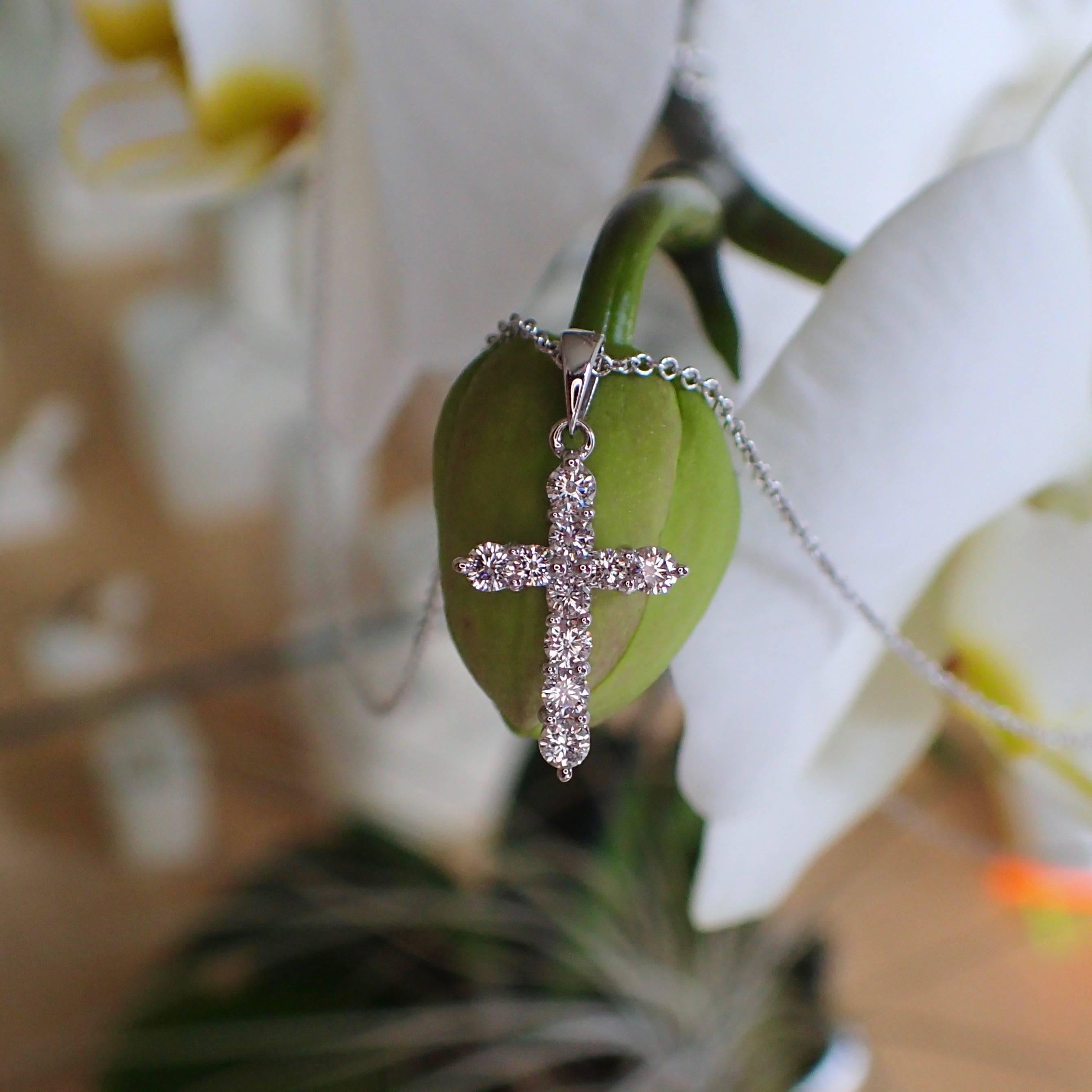 18k white gold thin cross with ten (10) Round Brilliant Cut diamonds weighing a total of 0.37 carats with Color Grade G and Clarity Grade VS. The cross weighs 0.70 grams. The cross measures 19.95mm in length, including the bail and 10.65mm in width.