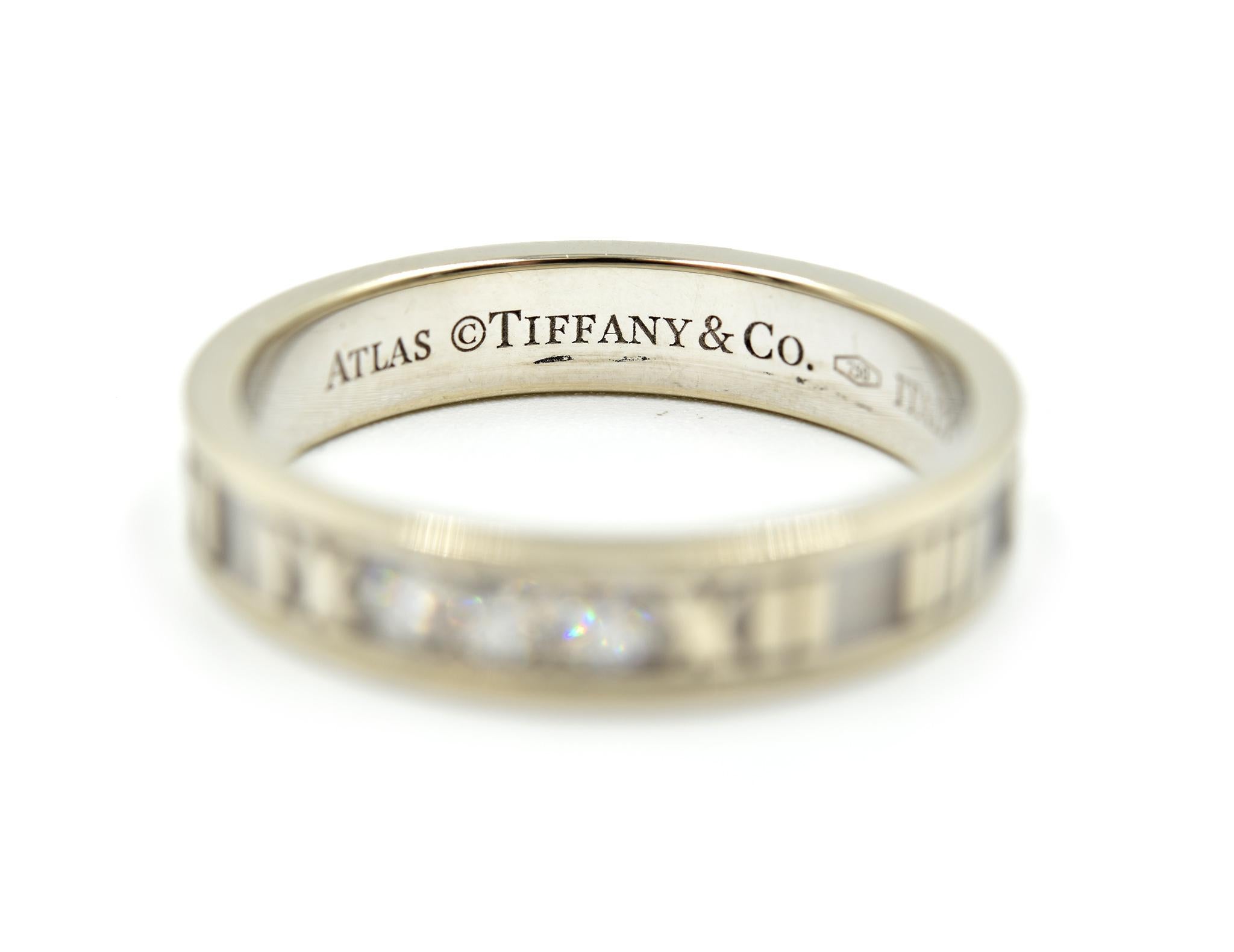 This band exhibits graphic sophistication and bold simple features. This is an authentic Tiffany & Co. band from the Atlas collection. This ring was made in 18k white gold, and set with 3 diamonds at the head of the ring. The diamonds have a