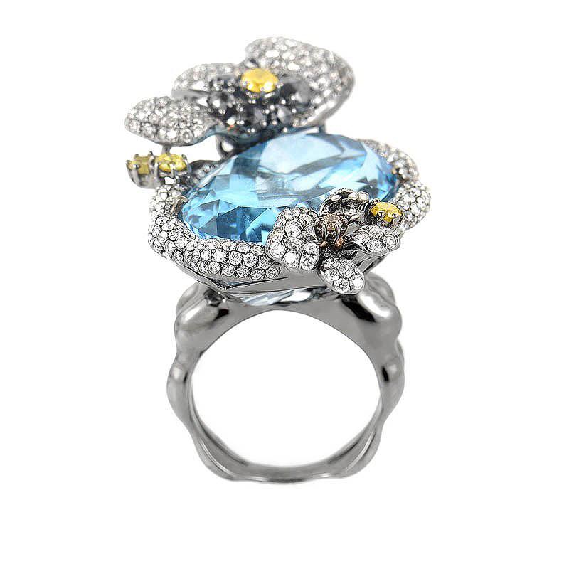 This ring is extravagant and colorful. It is made of 18K white gold dipped in black rhodium and boasts an ~40.79ct topaz stone accented with ~3.59ct of diamonds.
Ring Size: 6.5