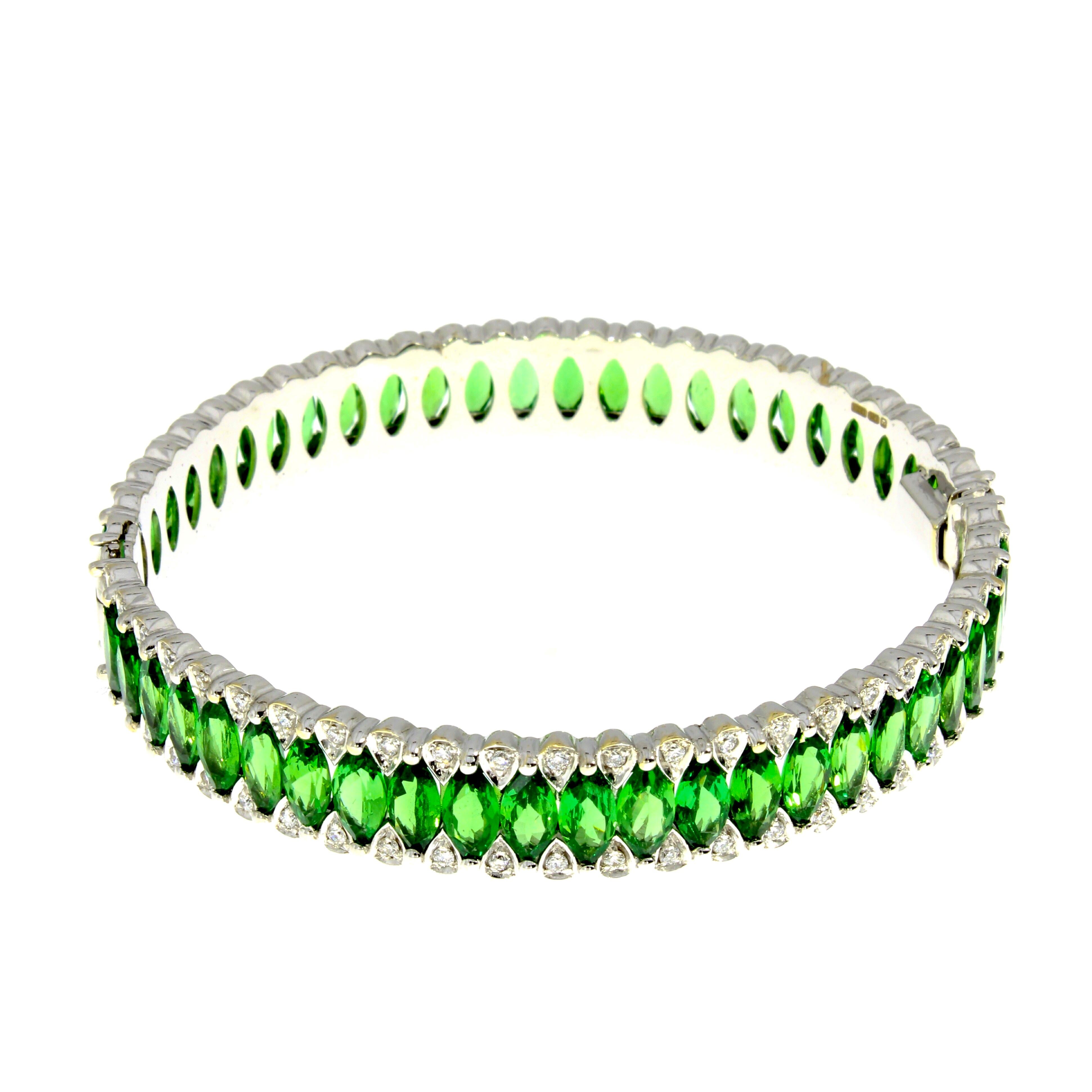 A perpetual circle of vibrant marquise cut tsavorites poised between two delicate rows of brilliant cut diamonds fluidly wraps around the wrist.

Details
- 18 karat White Gold
- 29.89 Carat Tsavorite
- 1.02 Carat Diamond

Diameter 2.3 inches