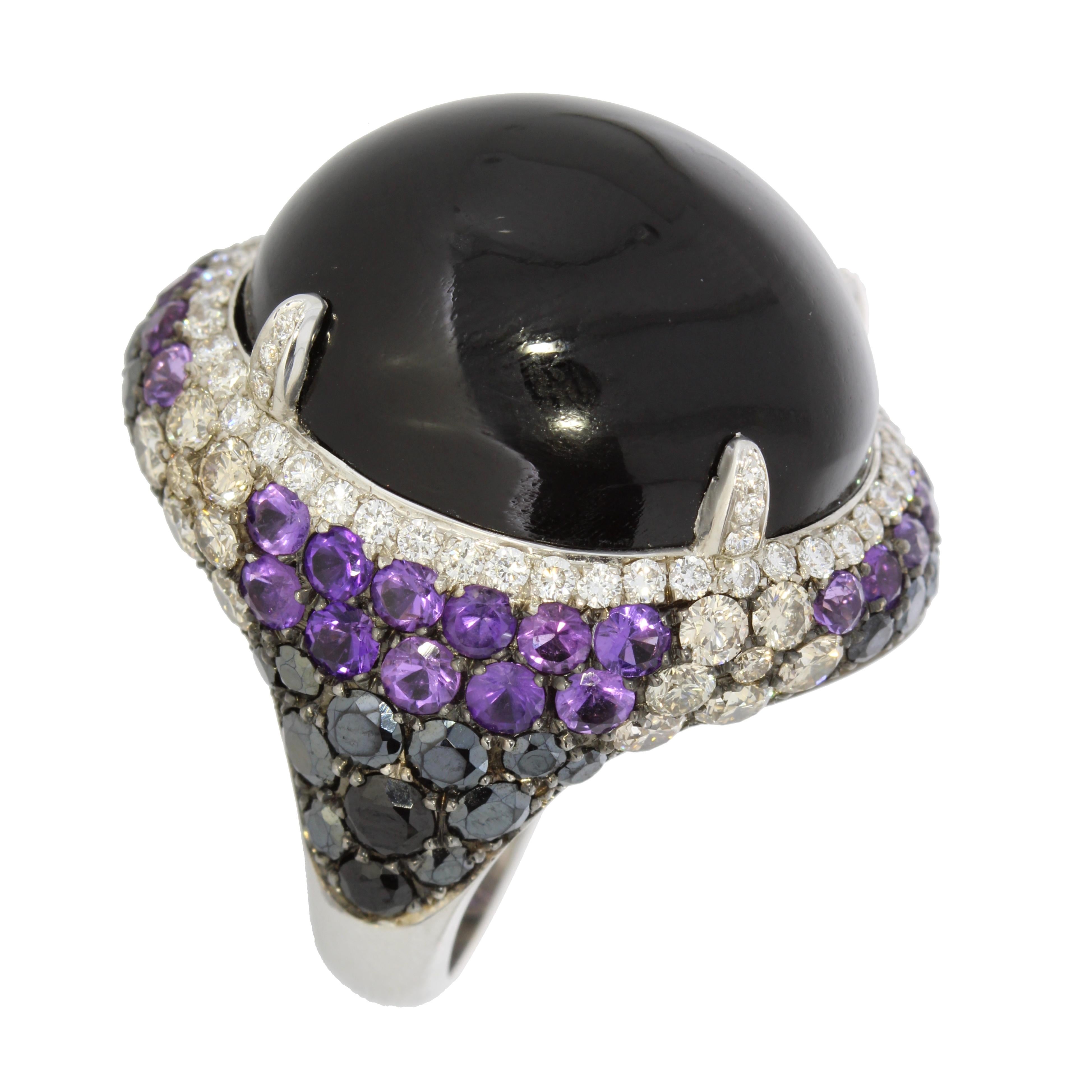 Evocative of the Carnival of Venice a daring black onyx cabochon surrounded by amethysts, black spinels and sparkling brown and white brilliant cut diamonds, form a majestic silhouette.

Details
Cabochon Onyx and Diamonds Cocktail Ring
- 18 karat
