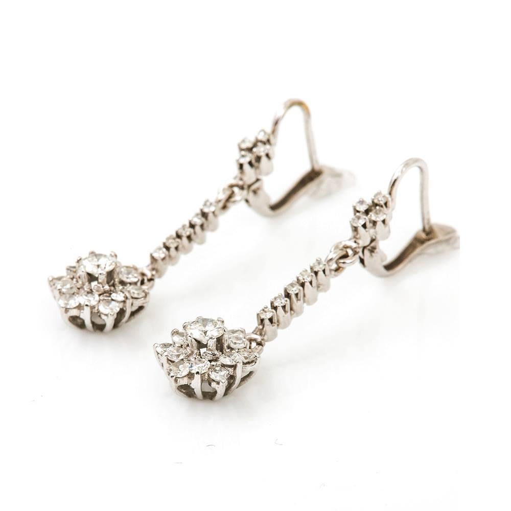 A pretty pair of 18k white gold diamond (est. O.75cts for the pair) drop earrings. The largest centre stone est. 15cts is brilliant-cut with the remaining stones being eight-cut diamonds. Securely set in 18k white gold French fastenings, these