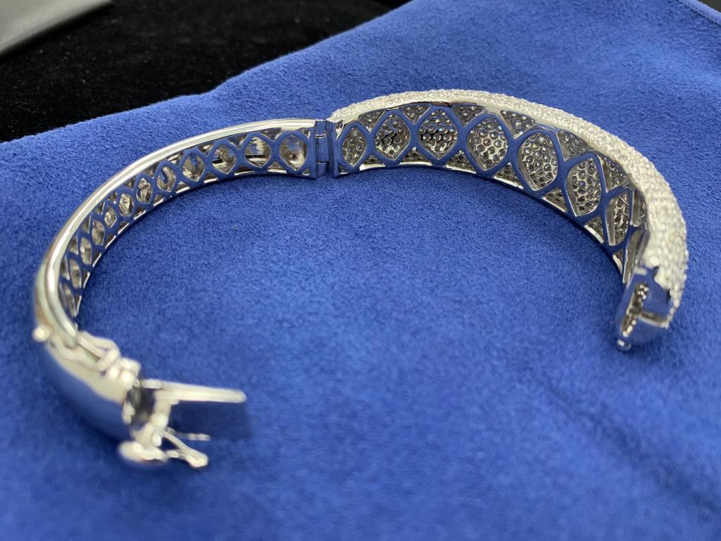 18k white gold micro pave diamond bangle with lock and approx 16 carats total weight of diamonds. 
