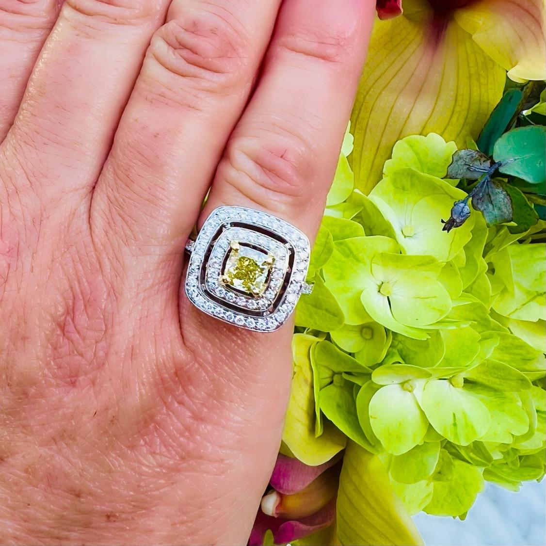A true showstopper. This 18 karat white gold stunner features a 1.01 carat Cushion Cut Yellow Diamond surrounded by a double halo of white diamonds. The vibrant yellow diamond has been graded with SI clarity and delivers a bright, sparkling yellow.