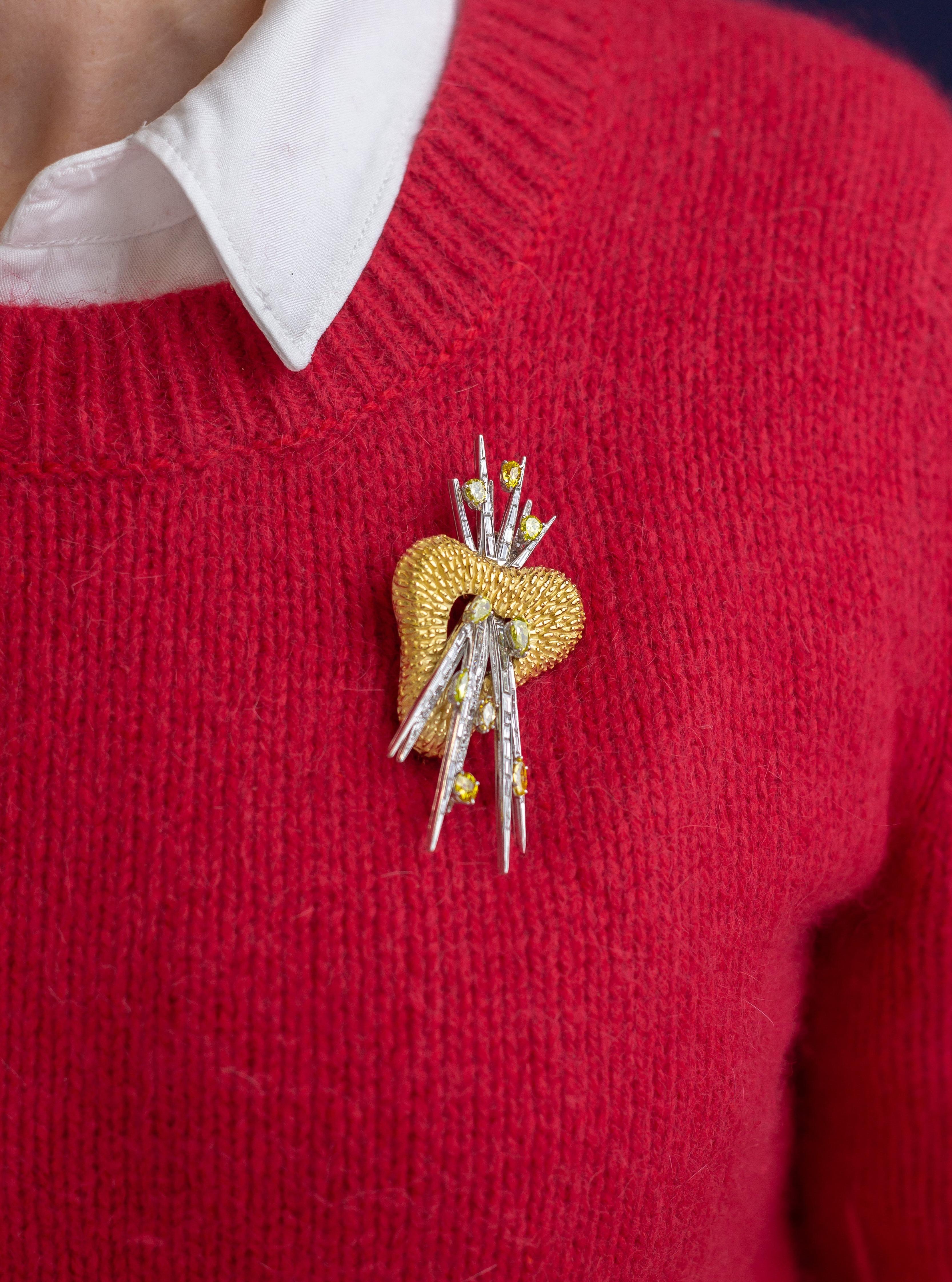 Cette broche audacieuse et bien conçue a été fabriquée en or jaune et blanc 18 carats et sertie d'un ensemble de diamants blancs et jaunes. La 