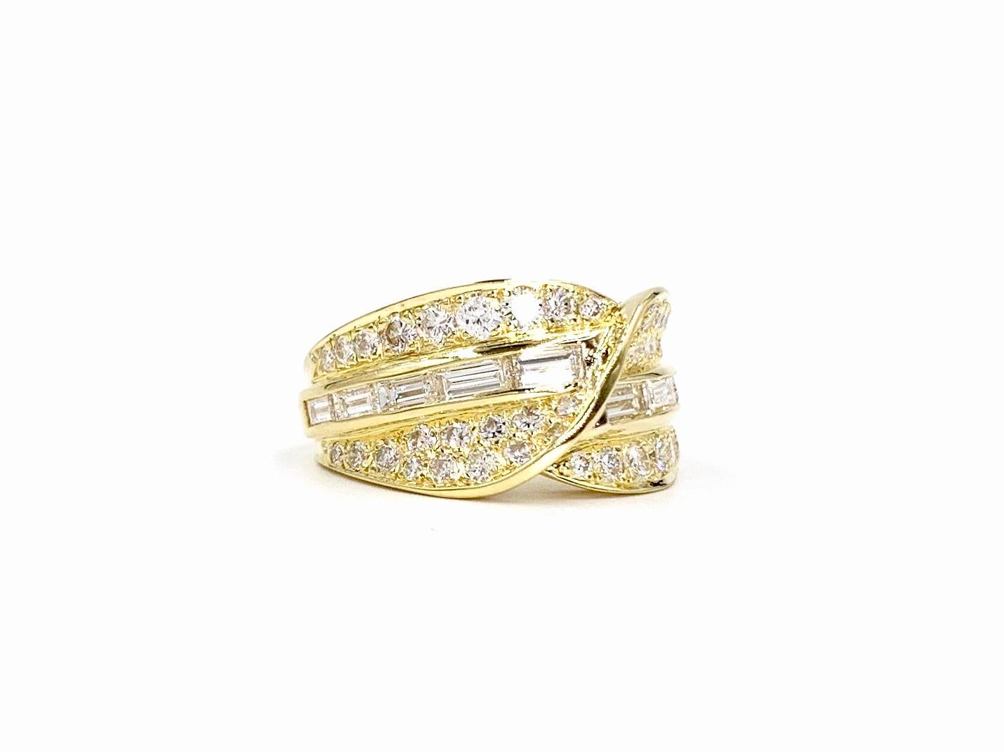 A wearable and very well made 18 karat yellow gold wide ring with a smooth and sleek design and a slight twist. This comfortable and low profile ring features 44 round brilliant diamonds at .85 carats and 10 baguette diamonds at .97 carats total