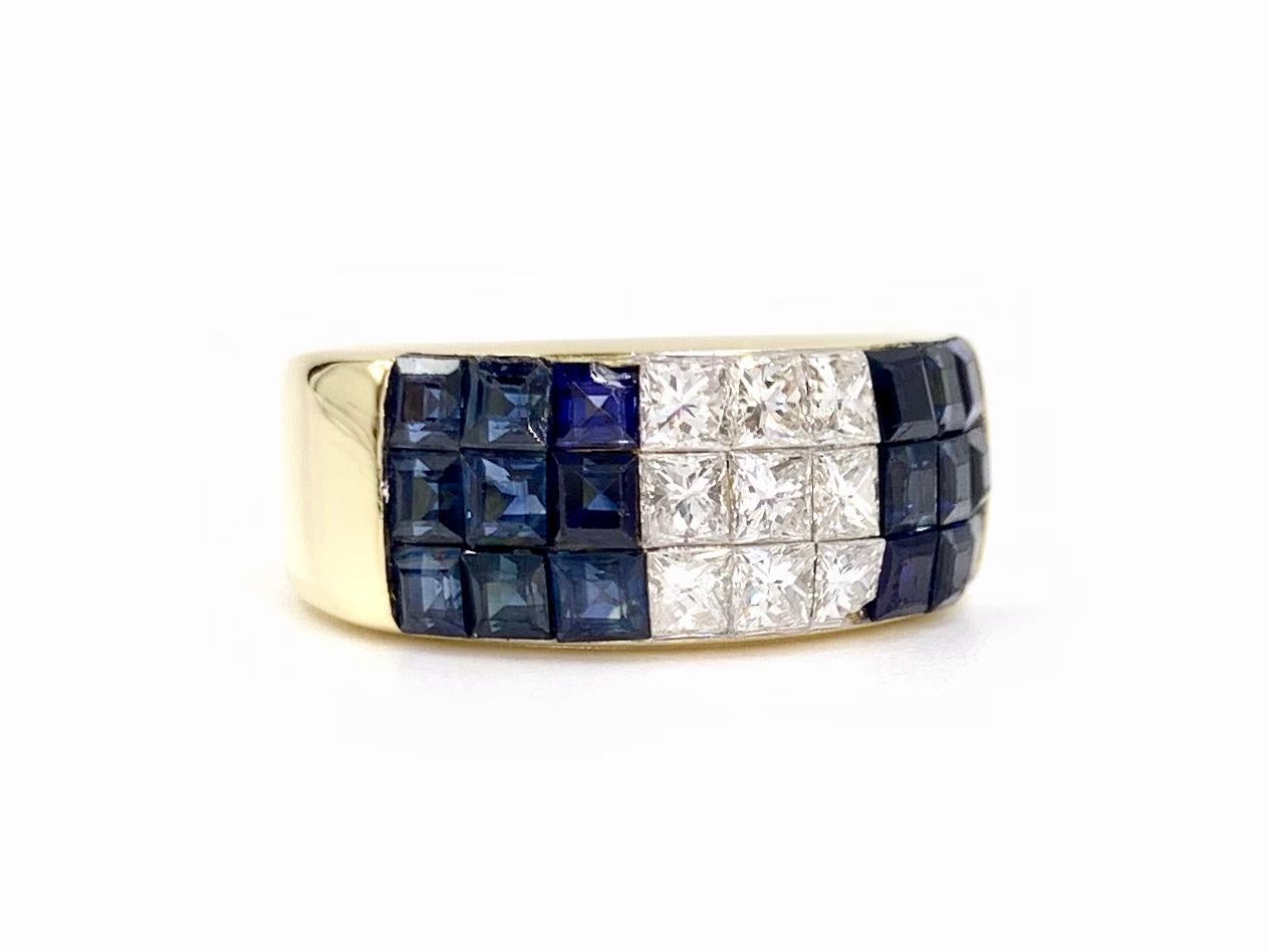 A sleek and modern invisibly set princess cut blue sapphire and diamond wide band style ring with generous sparkle. Made by Quadrillion Diamond Company, experts in invisibly set creations, this 18 karat yellow gold ring features 2.39 carats of well