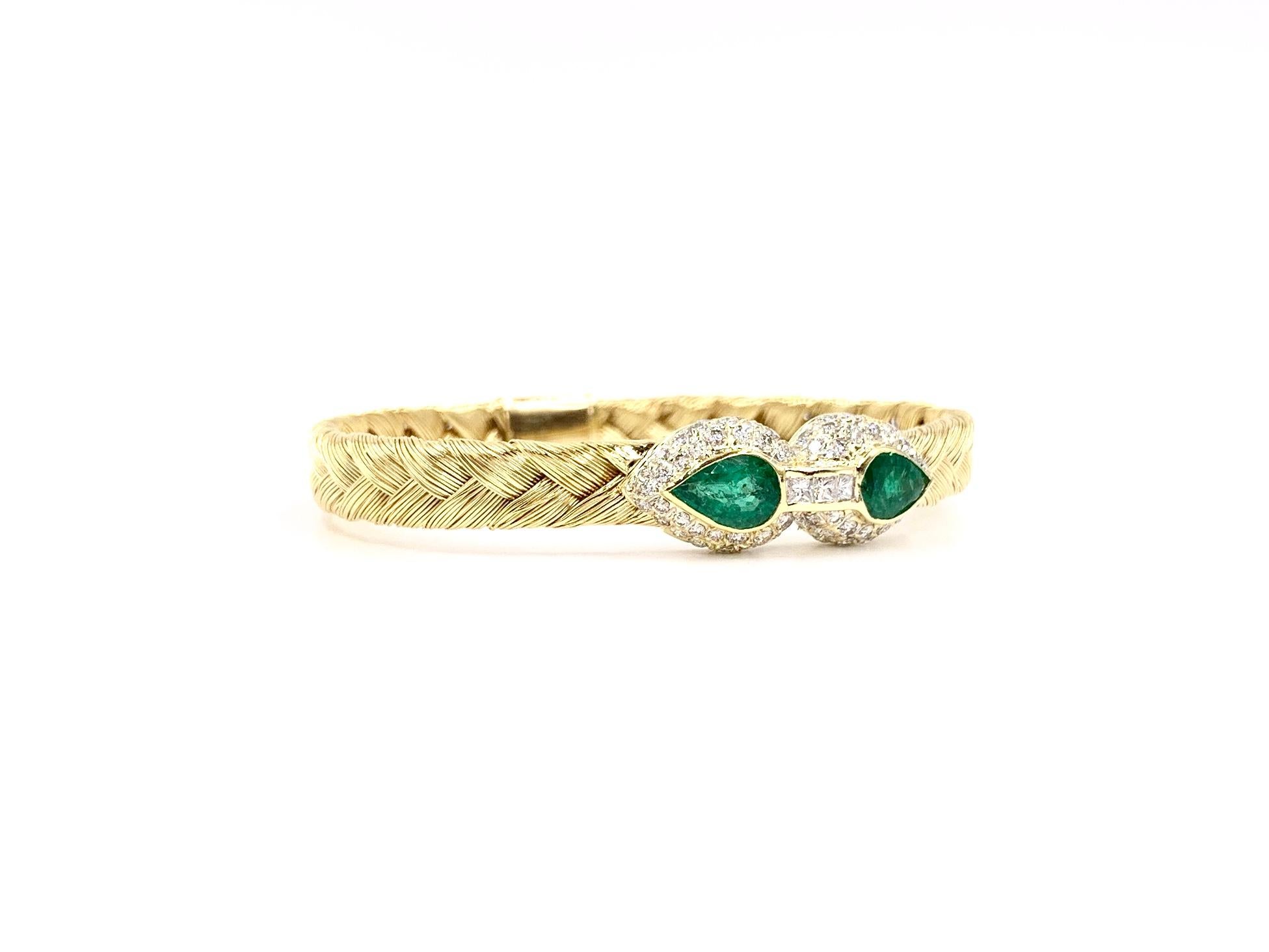 A comfortable, well made and simply beautiful 18 karat yellow gold bangle bracelet featuring two well saturated pear shaped emeralds at 1.68 carats total weight. Emeralds are surrounded by round brilliant diamonds and connected by three princess cut