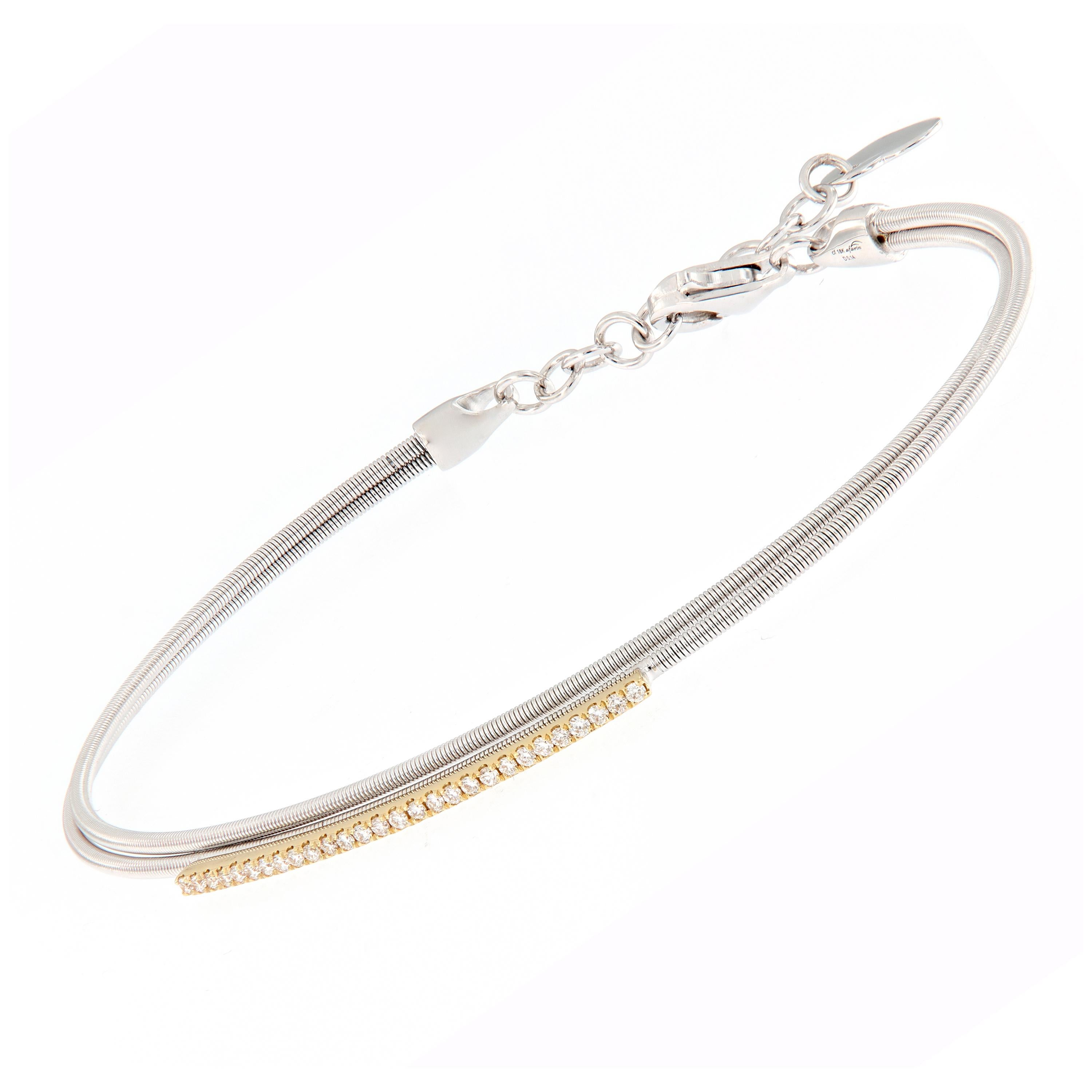 Wrap her wrist in the sparkle and comfort. This double wire bracelet is crafted in 18k white gold accented with a 18k yellow bar of diamonds. Bracelet secures with a safety chain clasp detailed with a heart dangle. 
18kWG & YG
Diamonds 0.14 cttw F-G