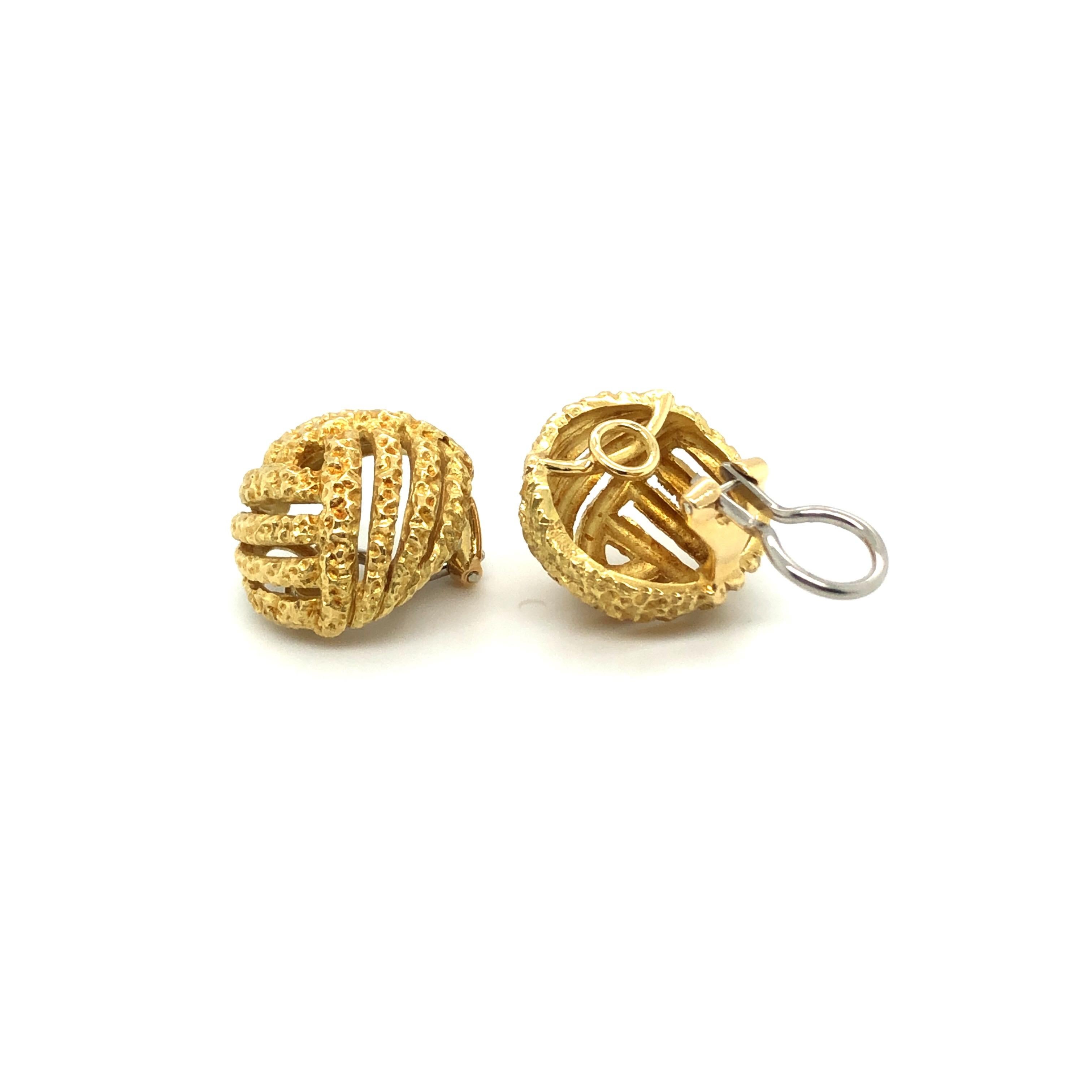 18 karat yellow and white gold earclips by renowned swiss jeweler Gubelin. 
These stylish earclips show a criss-cross pattern in 18 karat yellow gold. The textured surface is typically featured in jewels from the end of the 1960s to the beginning of