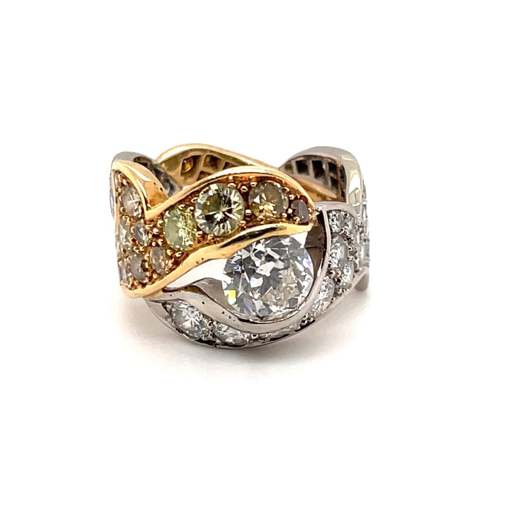 Elegant 18 karat yellow and white gold solitaire diamond band ring.

Eye-catching ring, designed as a series of intertwined, bicolor floral band motifs, pavé-set with white, respectively champagne- and cognac-colored brilliant-cut diamonds,