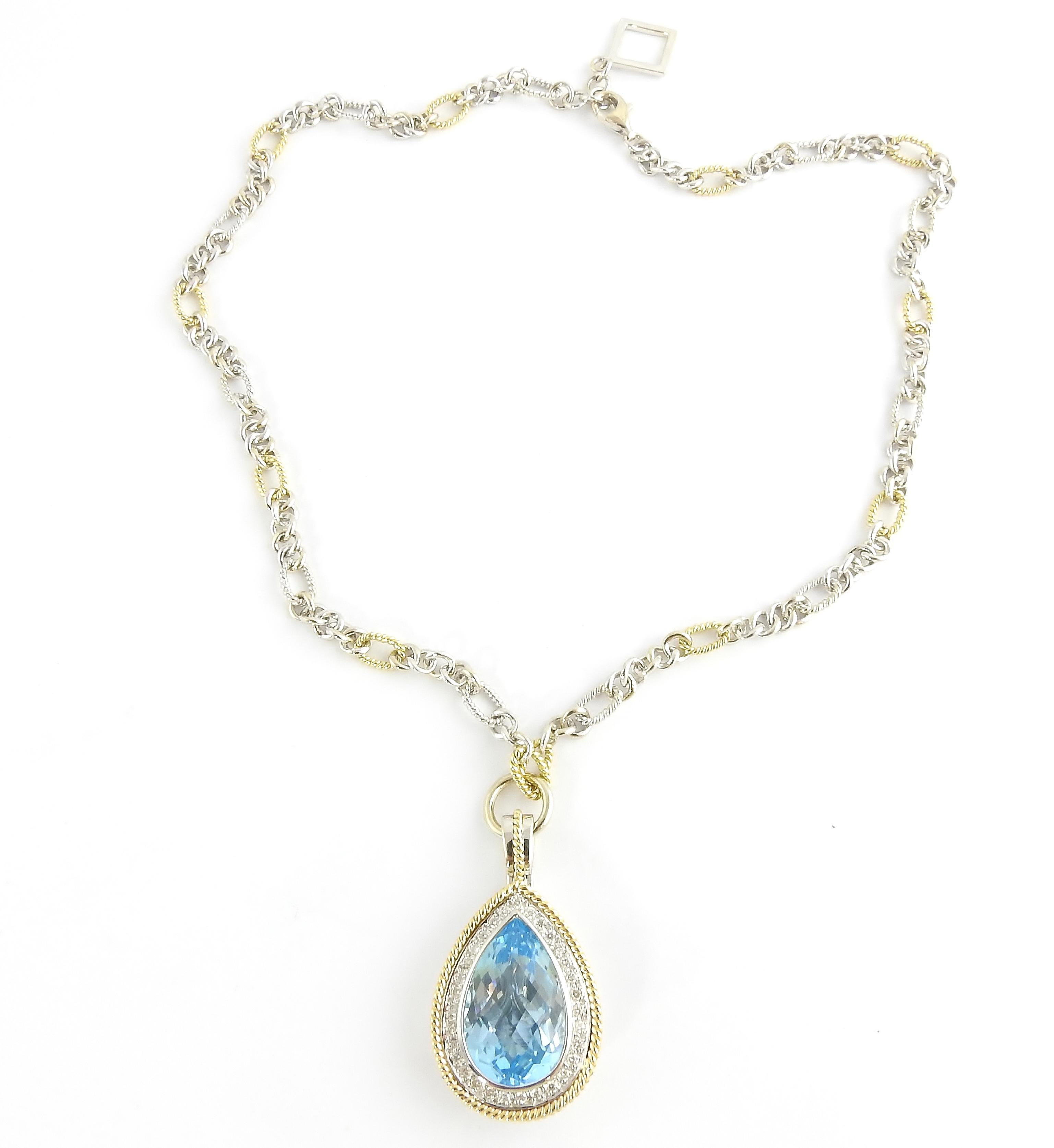 Vintage 18 Karat Yellow and White Gold Blue Topaz and Diamond Pendant Necklace-

This spectacular pendant features one pear-shaped blue topaz (21 mm x 13.5 mm) surrounded by 31 round brilliant cut diamonds and set in stunning yellow and white gold. 
