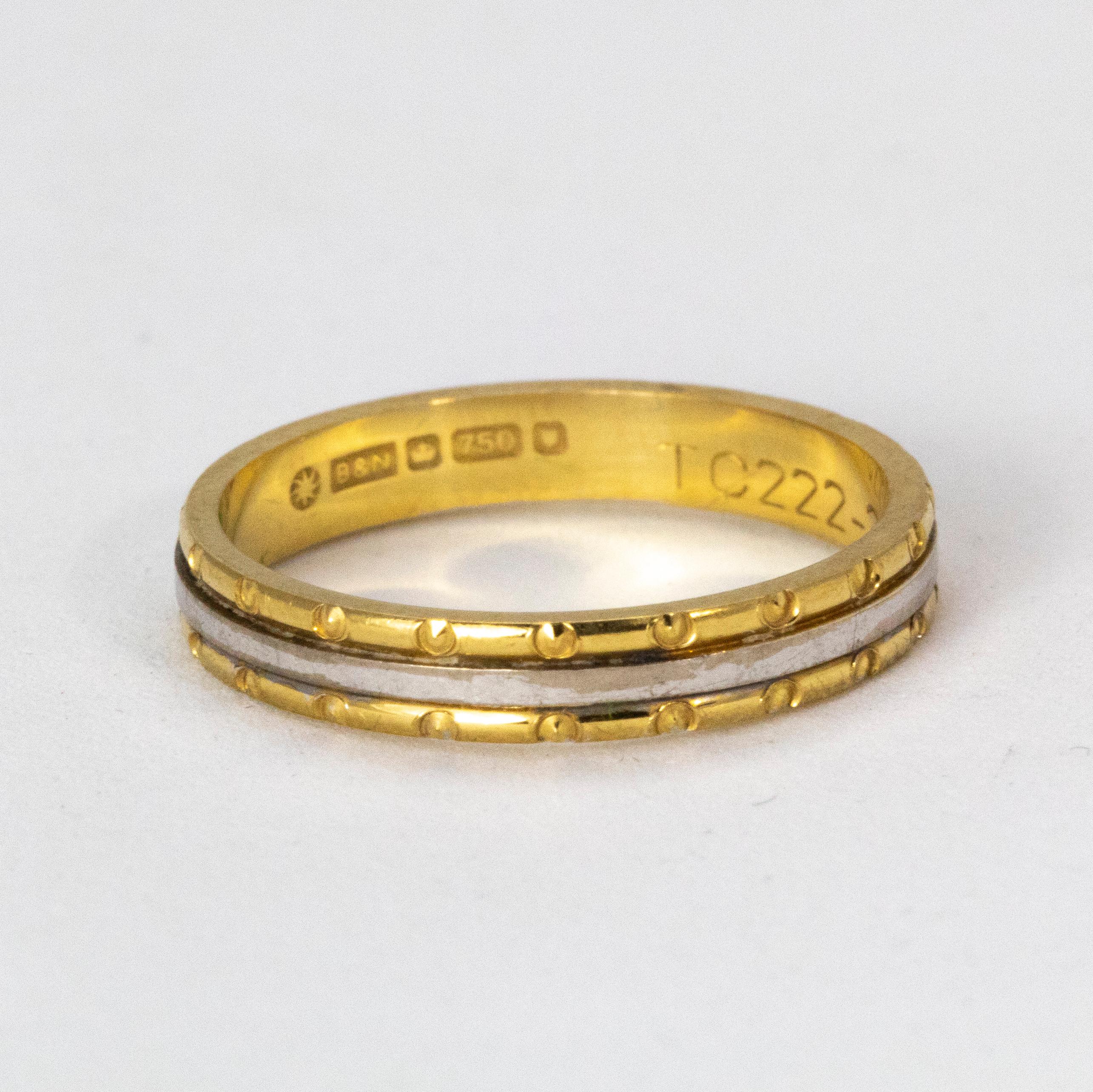 A Charming Wedding Band Composed of circle-stamped 18 Karat Yellow Gold with a central ring of White Gold, a truly delightful piece.

Ring Size: L or 6