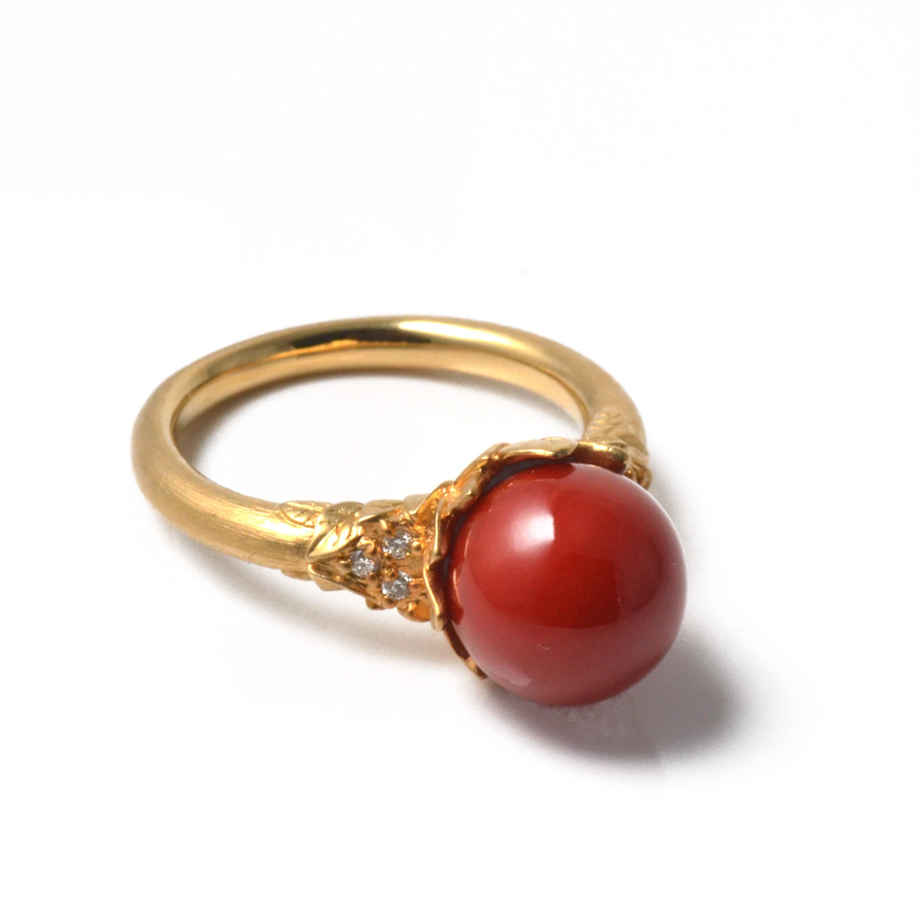 Nowadays, 10mm Chiaka Sango (oxblood coral) is very rare. This 18 karat yellow gold ring, with its botanical design and leaf motif, matte finish, and surface texture, is truly unique. Diamonds (0.06 carats total weight) enhance the coral’s beauty.