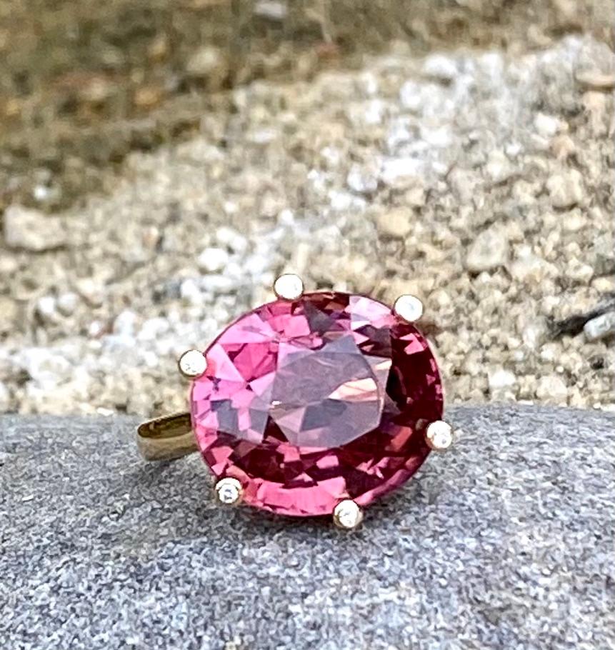 One-of-a-kind oval cut 11.83 carats of sparkling rubellite tourmaline and diamond cocktail solitaire ring, handcrafted in 18 karat yellow gold. US size 6.

This beautiful rubellite ring catches the light in so many ways through its rich, deep