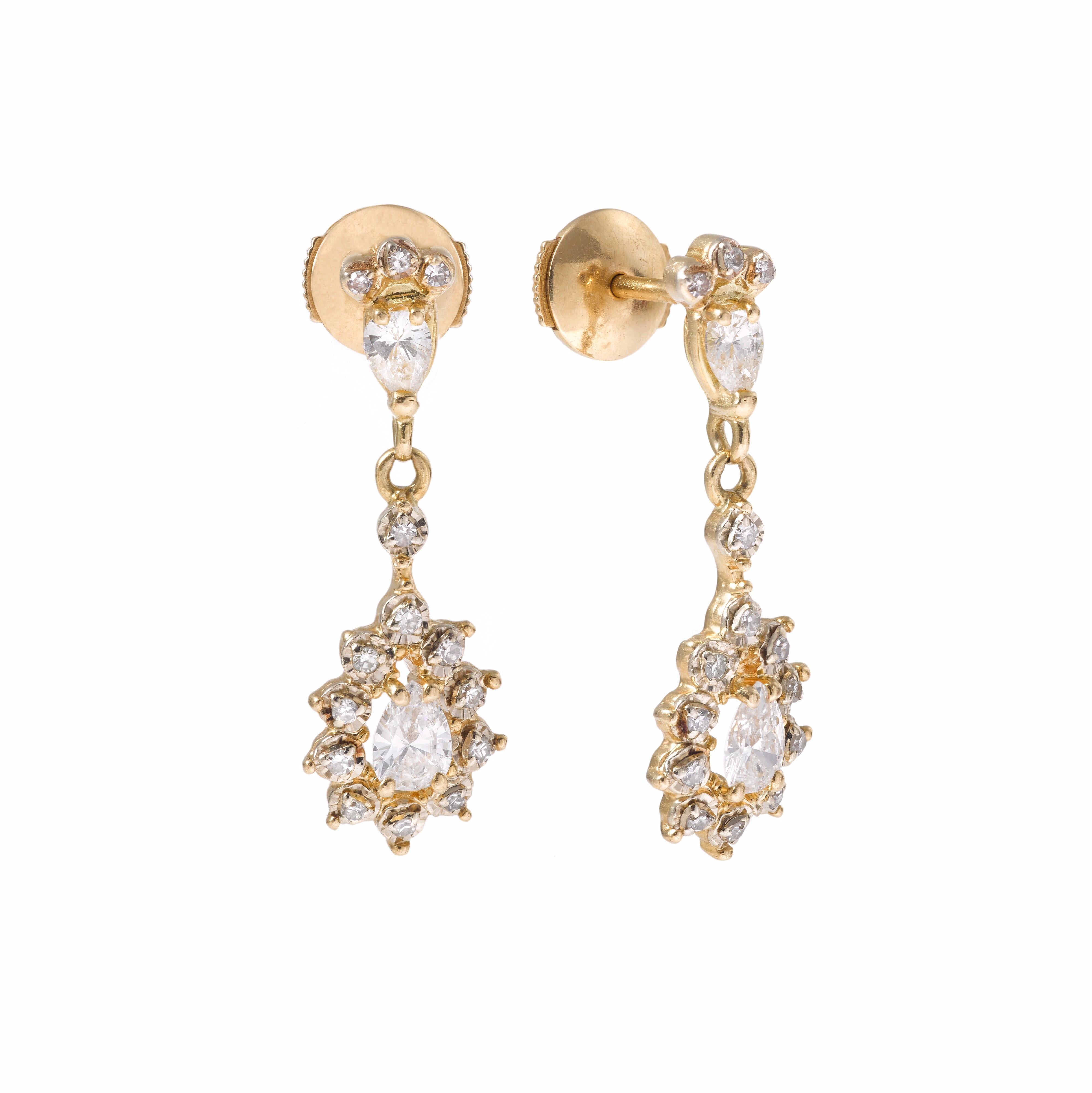 A fine and elegant pair of dangle earrings with 2 pear shape diamonds on each earring.
The top pear diamond with three little diamonds on top and the bottom pear diamond surrounded by 10 round cut diamonds.

2 pear diamonds approx. total weight 0.30