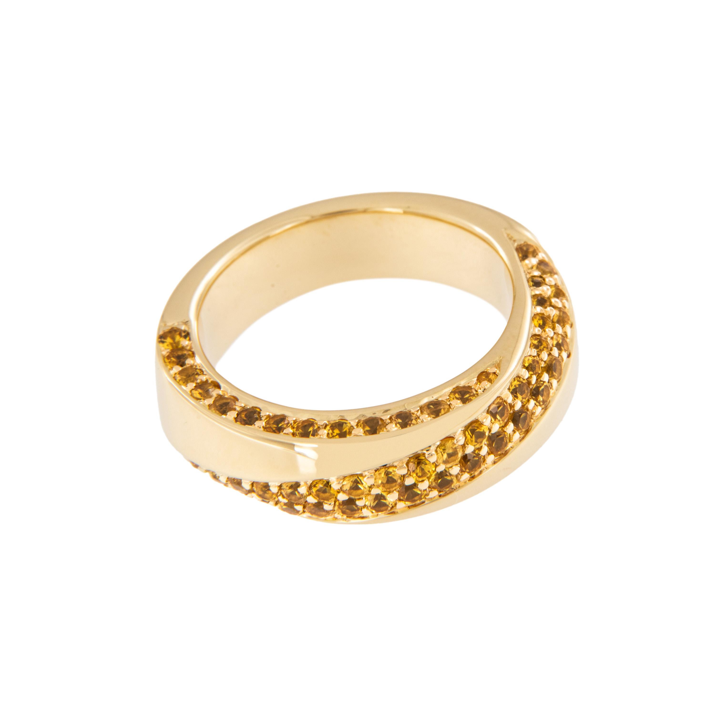 As bright as a sunny day! This gorgeous 18 karat yellow gold band ring features 70 round yellow sapphires pave' set in a twist pattern and on both outer edges for a beautiful, fluid movement you will love to look at while on your finger. Ring is a