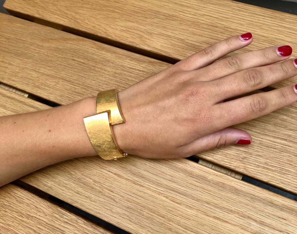 Wide textured 18 carat yellow gold 1970’s Cuff Bracelet with a feature overlap design. Made in Argentina. Fits a slim wrist. The cuff tapers around the back of the wrist. Closes securely with safety catch. Measures 3cms at the top where the overlap