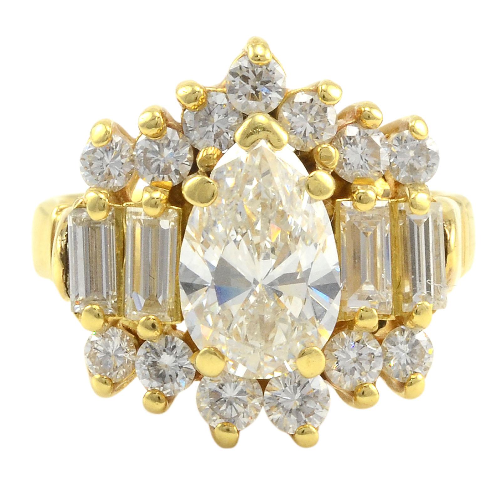 Estate 18 karat yellow gold 2.75 CTW multi diamond ring. This estate diamond ring has a center pear shaped diamond at 1.50 carats with VS2 clarity and H color, along with four baguette diamonds at 0.55 carat total weight and 13 diamonds at 0.70