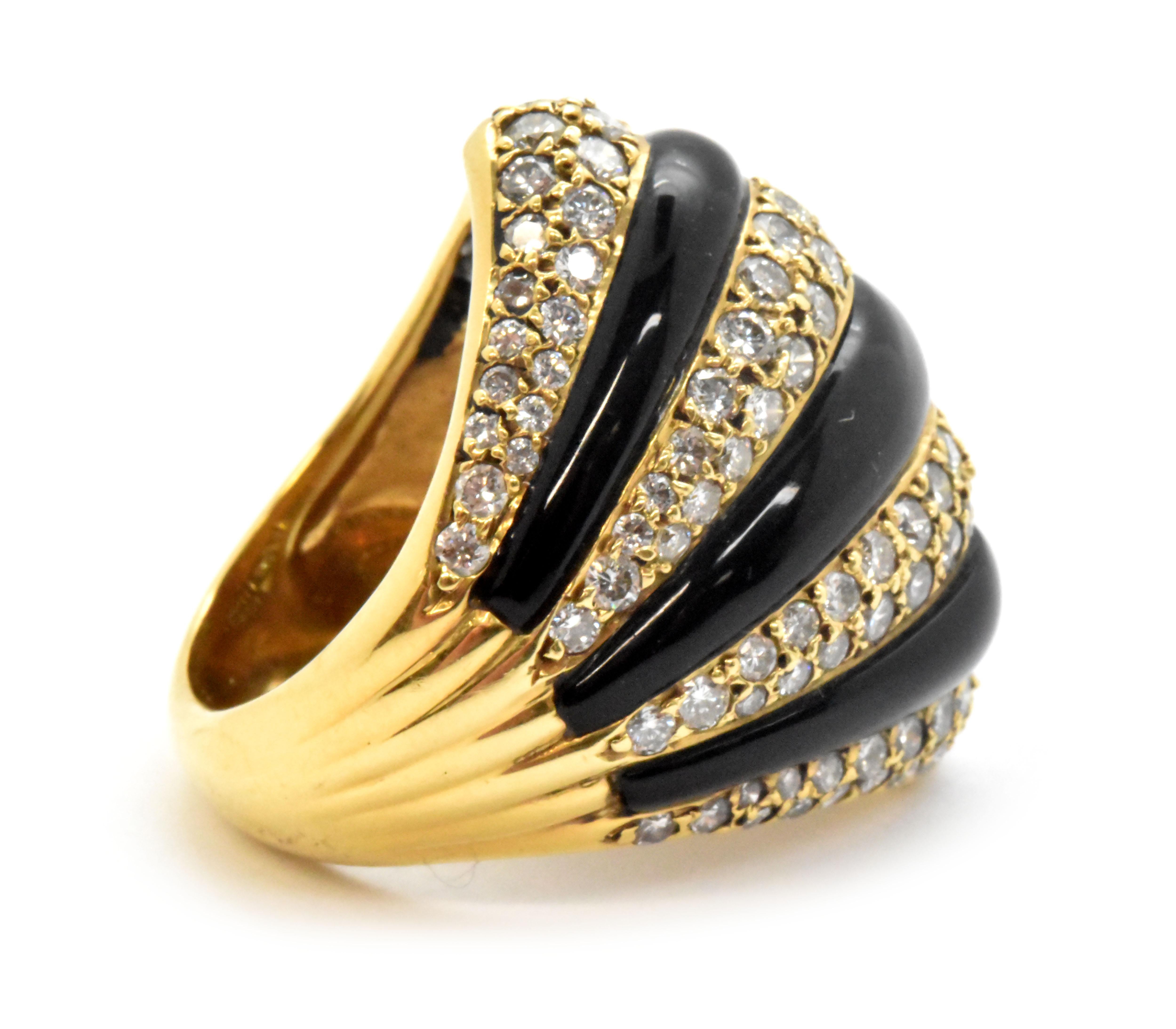 This ring is made in 18k yellow gold, and it is set with diamonds and onyx. The diamonds have a total weight of 2.80 carats, and the stones are graded G in color and VS in clarity. The ring measures 27mm wide, and it sits up 7mm high off of the