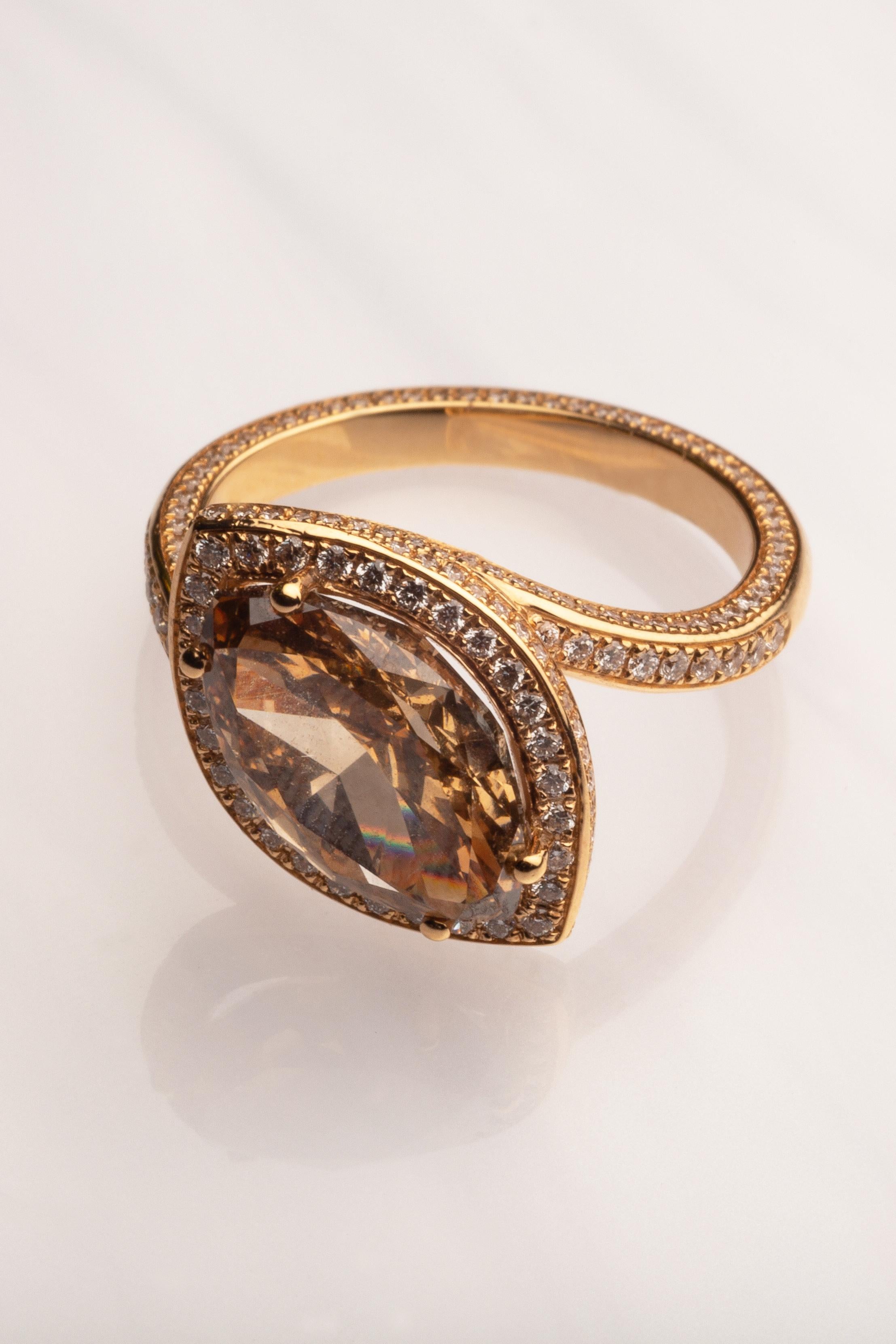 Dieser elegante Cocktailring aus 18 Karat Gelbgold ist aus unserer Divine Collection'S. Der Mittelstein ist ein brauner Diamant in Marquiseform mit einem Gesamtgewicht von 4,15 Karat, der von runden farblosen Diamanten mit einem Gesamtgewicht von