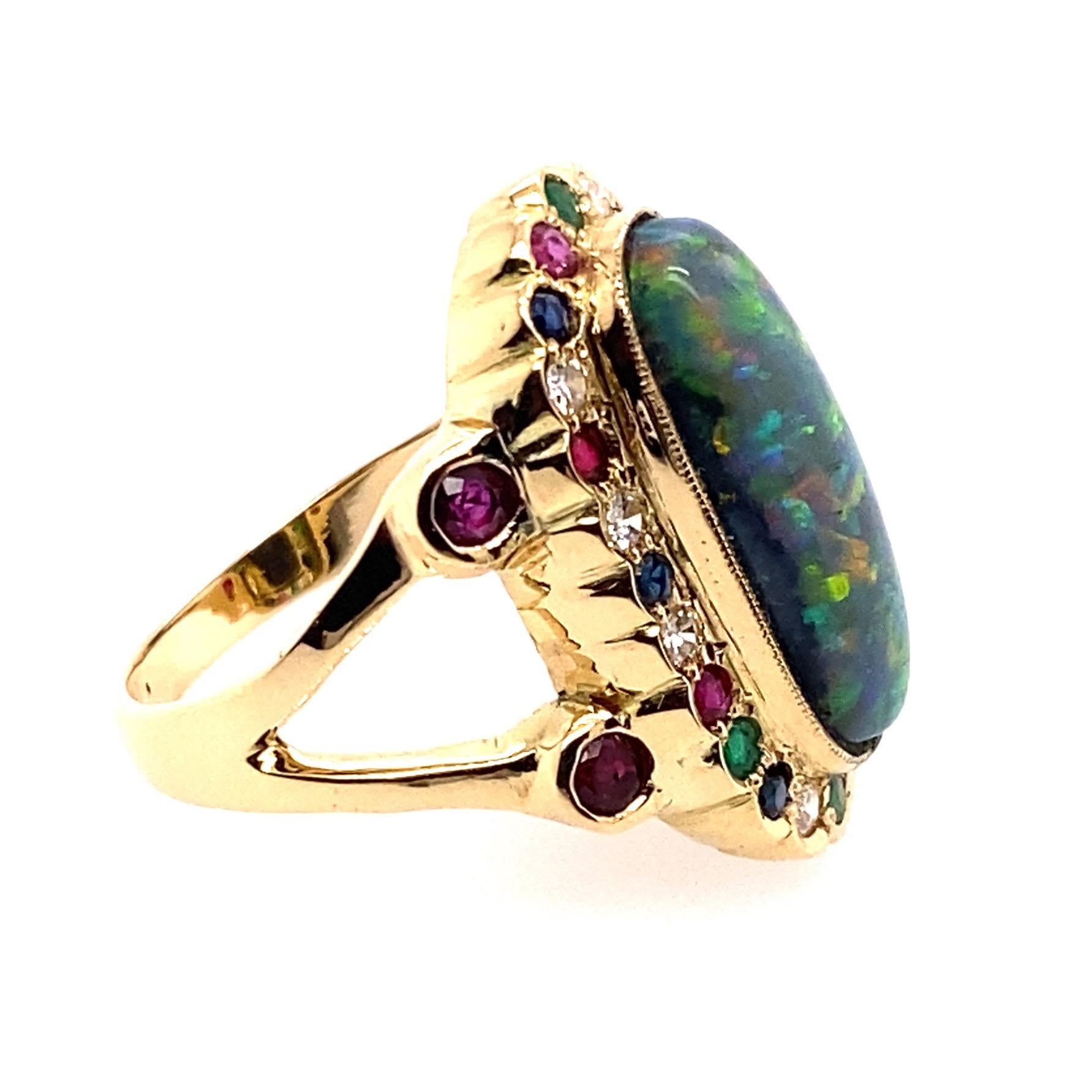 18 Karat Yellow Gold 4.60 carat Australian Black Opal Cocktail Ring

Center stone is oblong shape solid Australian black opal set in a bezel setting. Surrounding the opal are diamonds, rubies, blue sapphires and emeralds forming a cluster head.