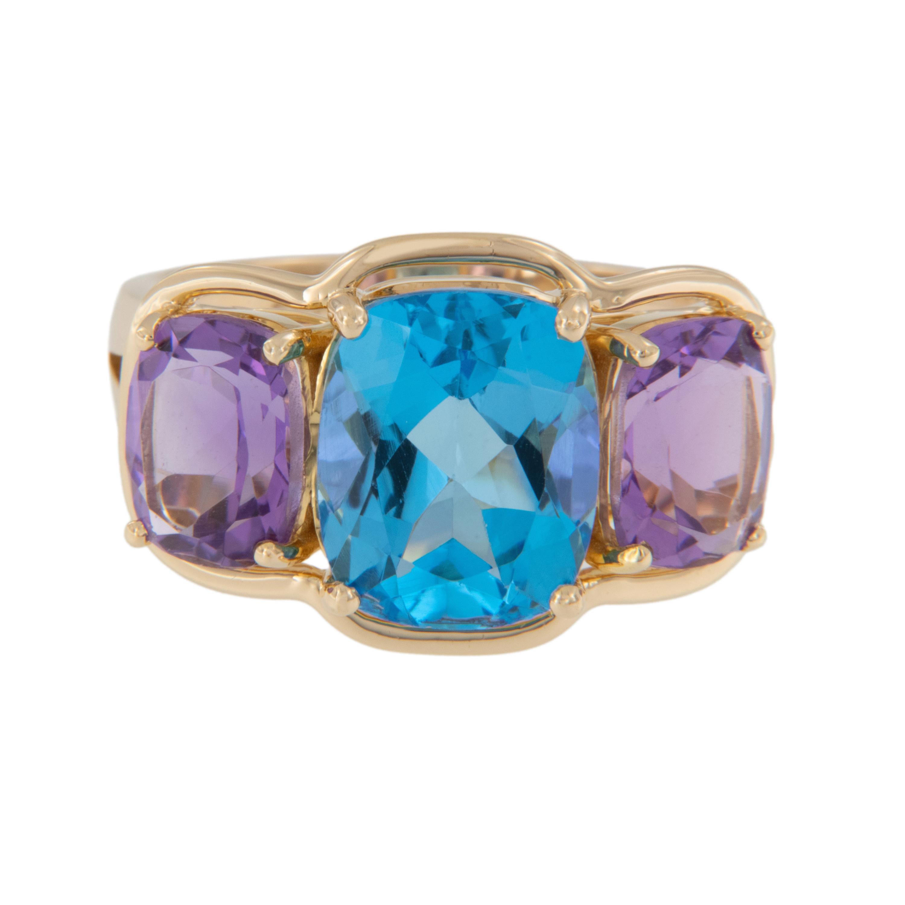 Powerful color combination of bright sea blue and romantic purple, all in this lovely three gem ring! Three stone rings represent today, yesterday and the future.  Crafted in rich 18 karat yellow gold, this fun ring features a 5.29 Ct cushion cut