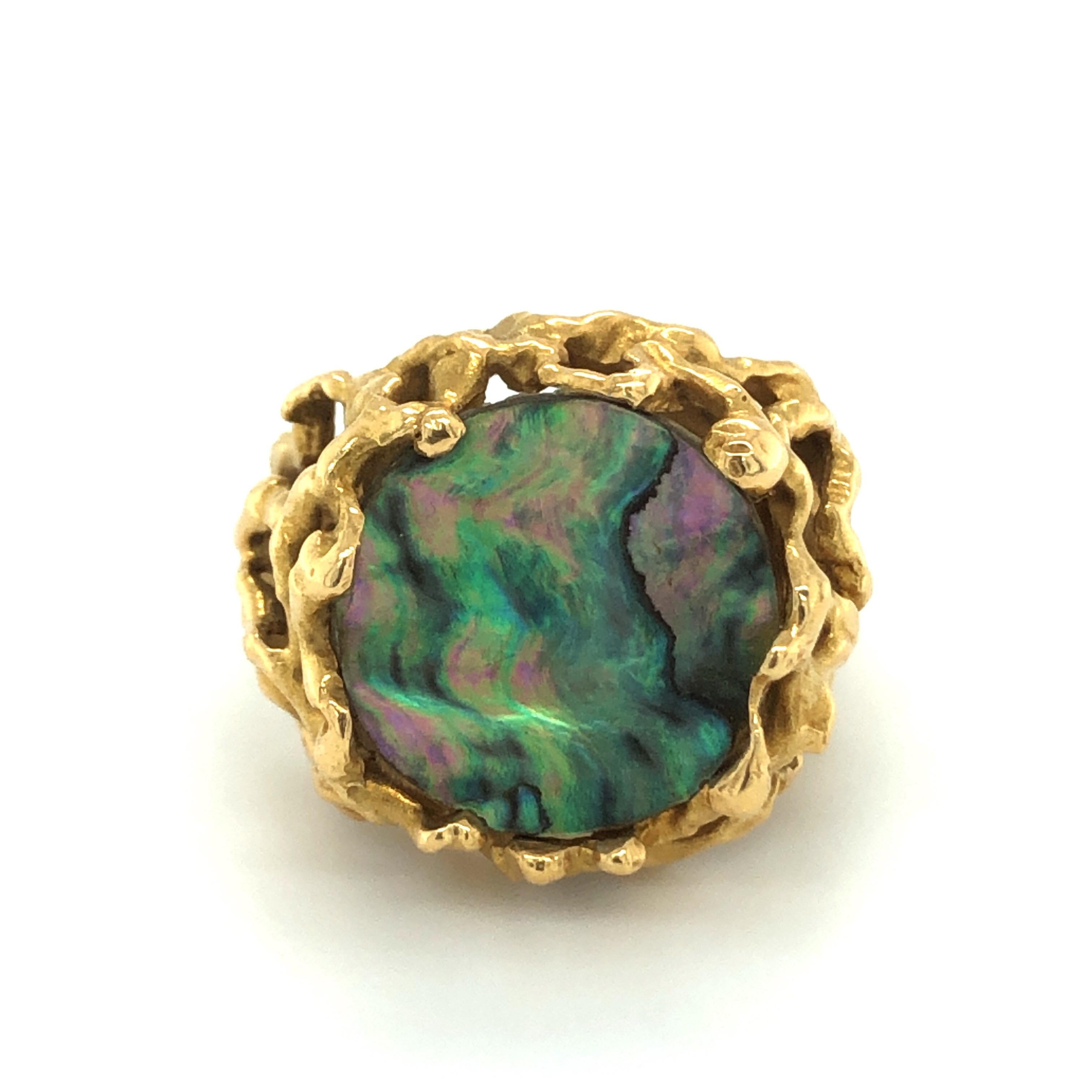 18 karat yellow gold abalone 1970s ring by renowned Swiss jeweler Gubelin.

Eye-catching 18 karat yellow gold ring designed as a bundle of tangled branches and set with a round iridescent abalone platelet. The irregular appearance of the gold mount