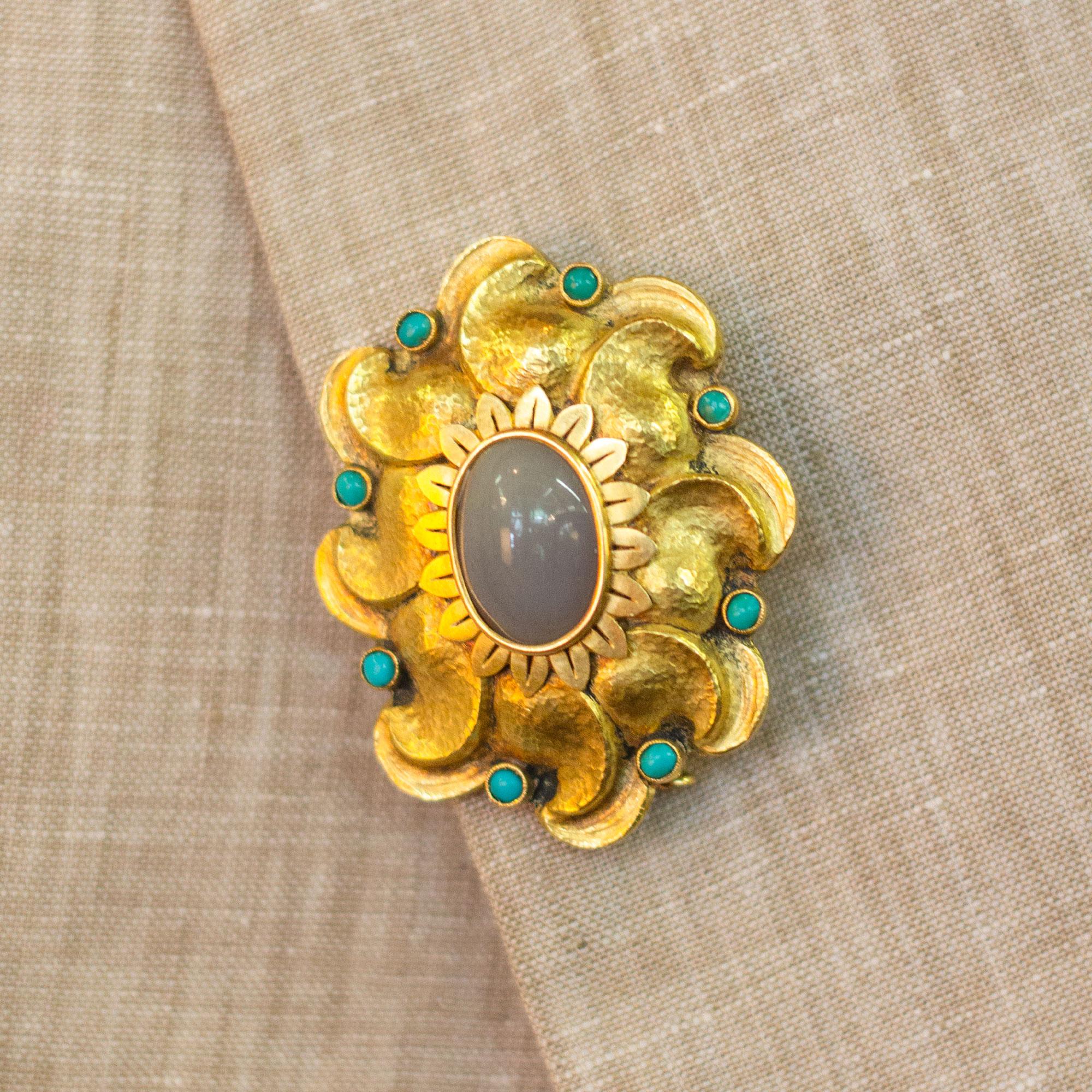 An 18kt hammered yellow gold, agate and turquoise brooch pin. This piece is finished beautifully with cabochon cut turquoise pieces and a large cabochon agate in the centre, surrounded by gold flower petals. The hand sculpted and hammered gold is