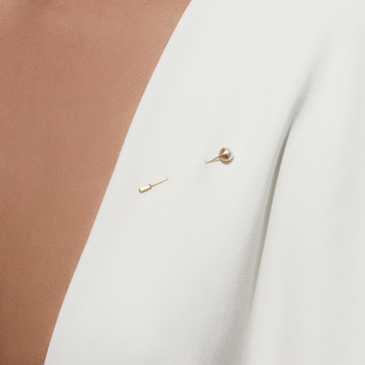 This lapel pin features a pearl set in a half sphere of gold at a 0 degree angle. Comes with an 18K yellow gold pin stopper. 

18 Karat Yellow Gold Akoya Pearl Lapel Pin 0°
Pin length: 43mm
Stopper: 7mm
Akoya pearl: 7mm
This item is made-to-order