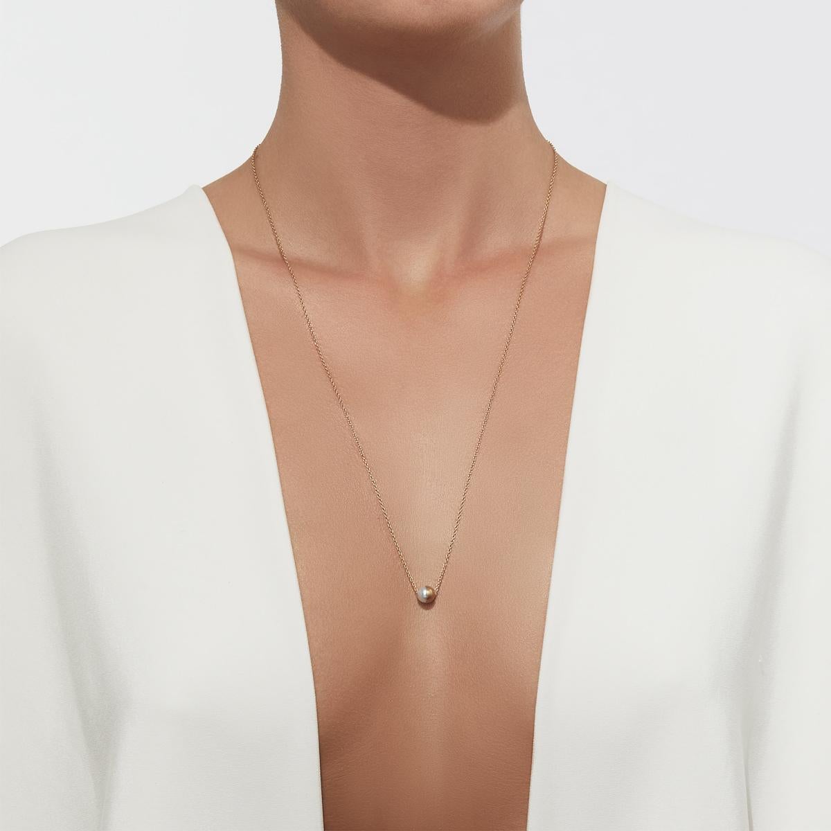 A pearl is encased in a half sphere of gold at a 90 degree angle. The long chain is looped through the pearl pendant and can be worn over the head. 

Chain length: 650mm
Akoya pearl: approx. 7mm
This item is made-to-order but in some cases may be in