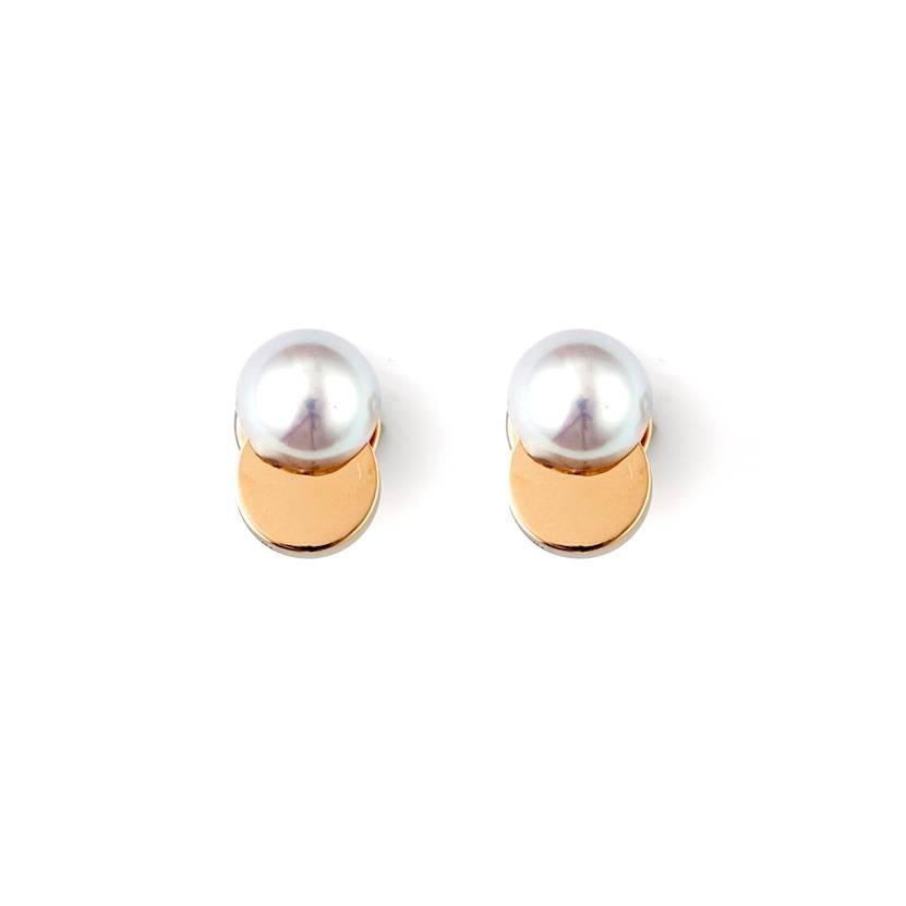 These earrings feature Akoya pearls of a silver grey hue cut in half and placed on a plate of 18 karat gold, allowing the contrasting materials to show through. The earring backs are made of half a pearl and gold and is a reversible