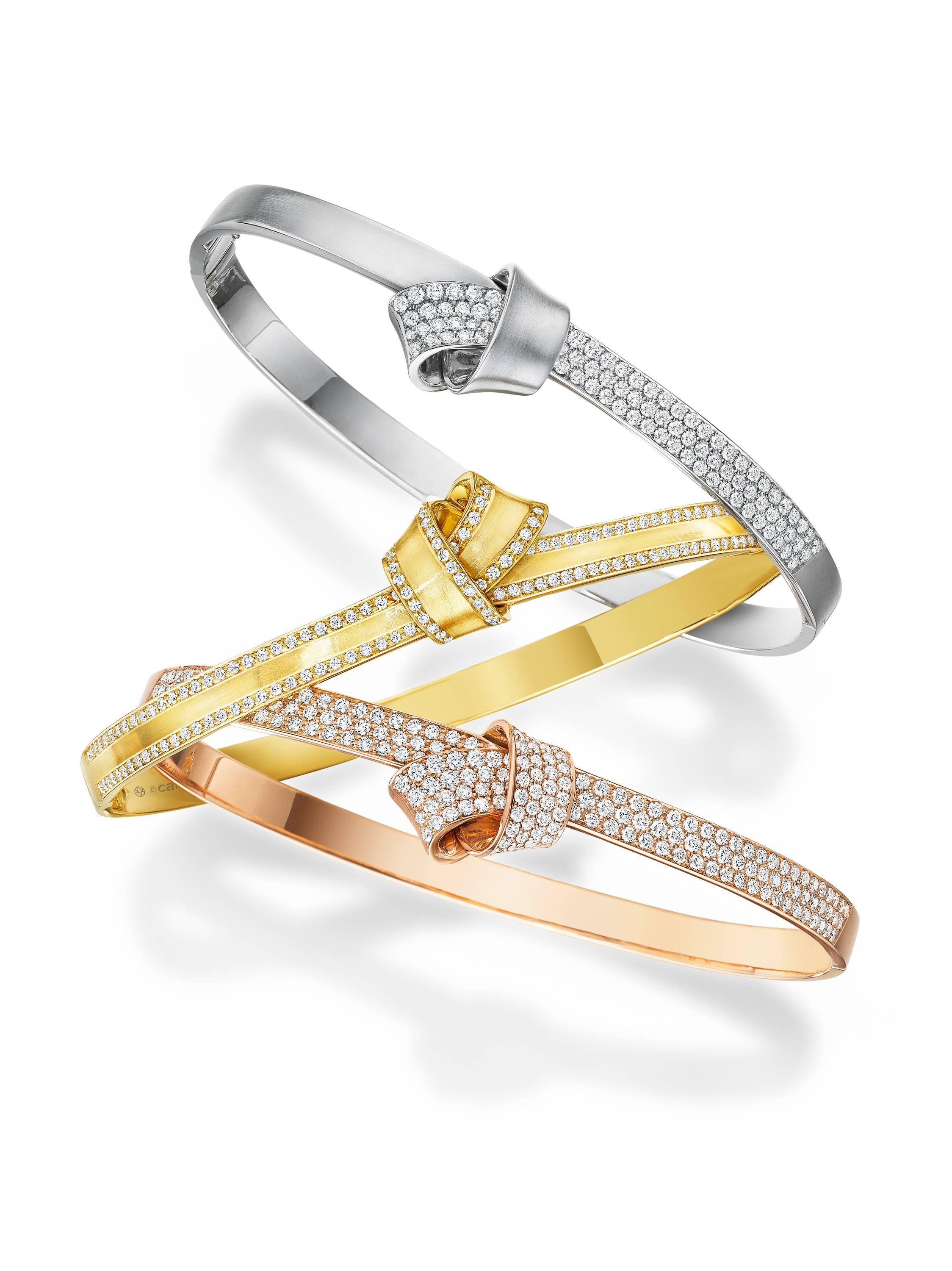 Trimmed in .71 carats of sparkling pave diamonds, folds of sumptuous 18k yellow gold encircle the wrist as a reminder of love. This structured, elegant bangle gives you around-the-clock glamour.  The bangle features a safety lock closure for