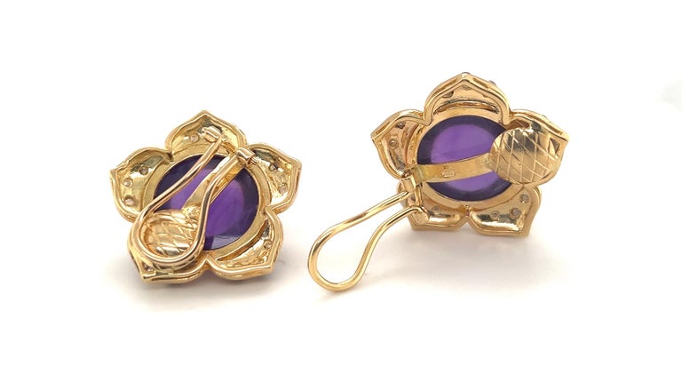 Ladylike pair of 18 karat yellow gold and amethyst flower earclips.
Crafted in 18 karat yellow gold and designed as a pair of flowers centering upon 2 round amethyst cabochons totalling circa 36 carats. The flower petals are of high polish and