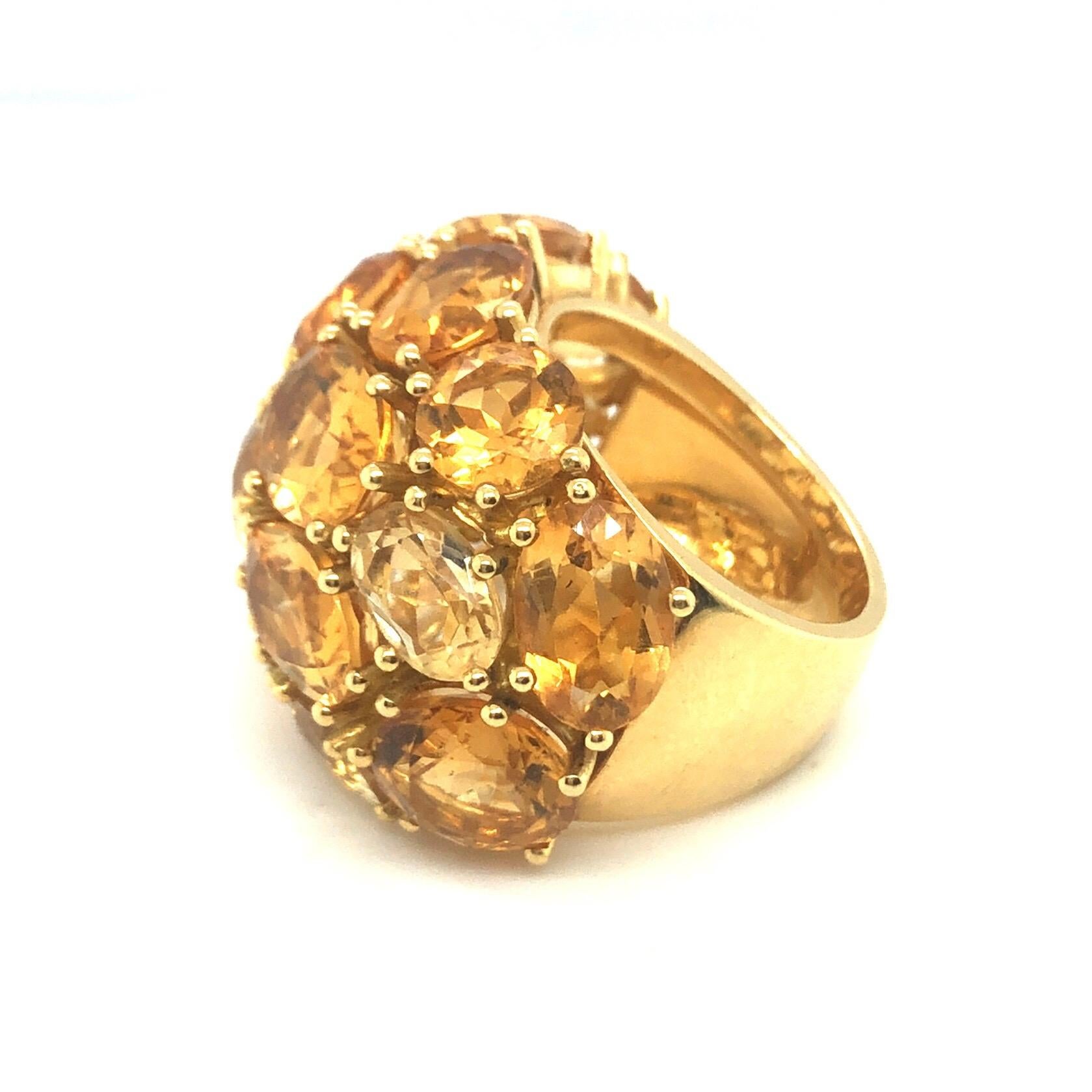 Splendid 18 karat yellow gold and citrine cocktail ring, circa 2000.
Crafted in 18 karat yellow gold, the dome set with 16 round and oval citrines of slightly different yellow shades totalling circa 25 carats, this statement ring is just perfect for