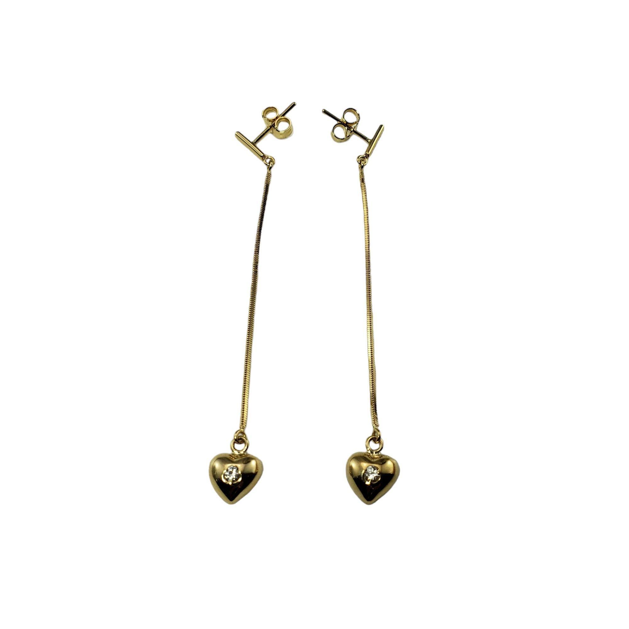 18 Karat Yellow Gold and Diamond Dangle Heart Earrings-

These elegant dangle heart earrings each feature one round brilliant cut diamond set in classic 14K yellow gold. Push back closures.

Approximate total diamond weight: .10 ct.

Diamond