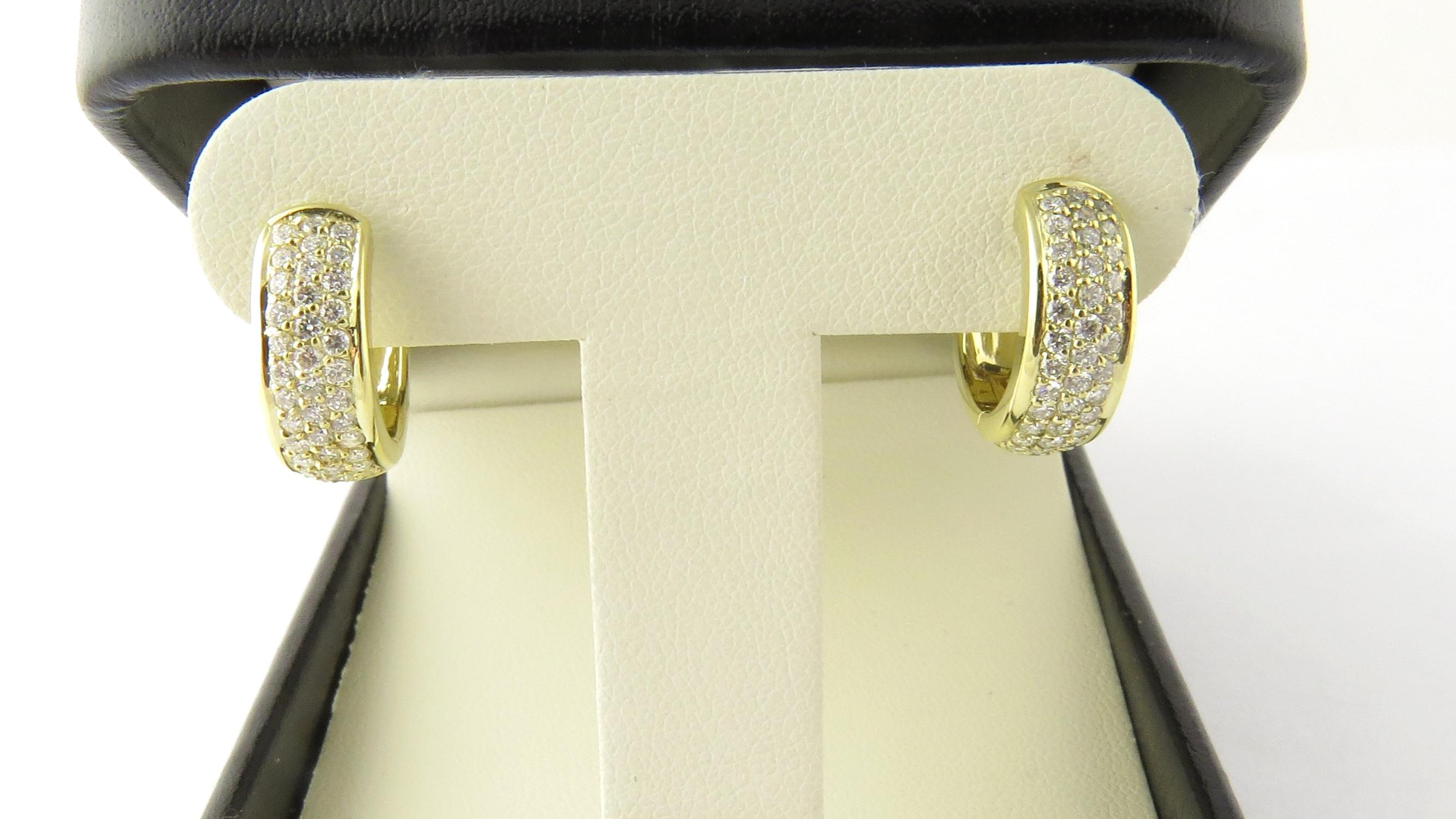 Vintage 18 Karat Yellow Gold and Diamond Huggie Earrings

These sparkling huggie earrings each feature 37 round brilliant cut diamonds set in classic 18K yellow gold. 
Width: 5 mm.

Approximate total diamond weight: .74 ct.

Diamond color: