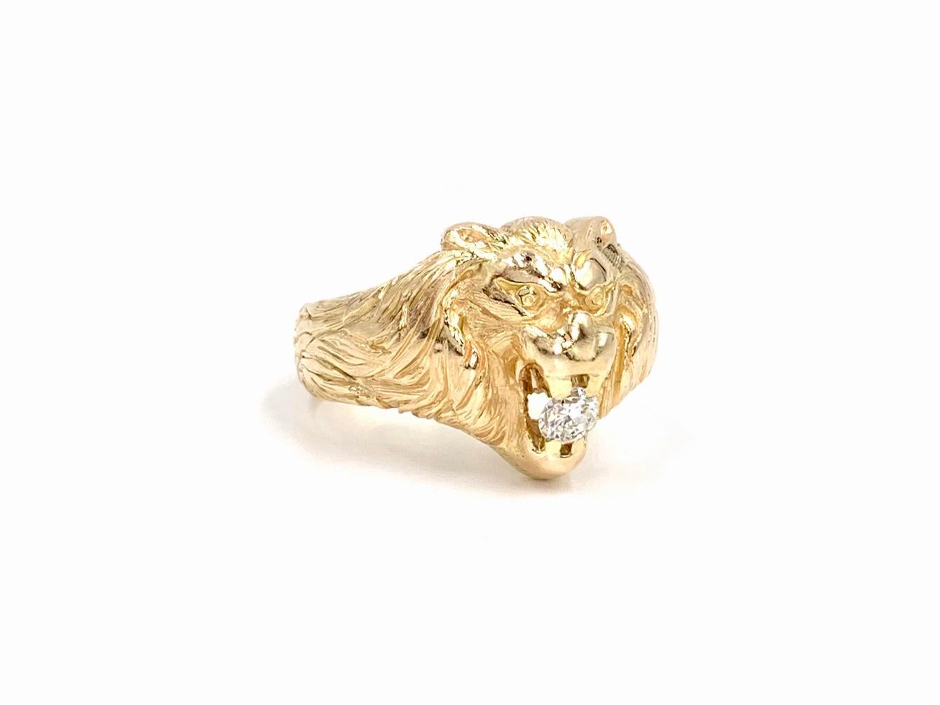 A roaring lion holds a sparkling round brilliant diamond between his teeth in this unique carved 18 karat yellow gold ring. Diamond is approximately .15 carats at approximately I color, VS2 clarity (eye clean). Lion head ring has a substantial