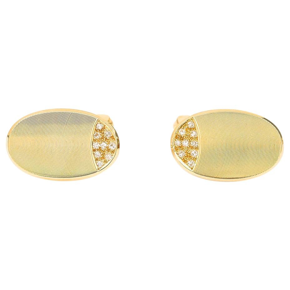 A smart and attractive pair of 18 karat yellow gold oval pair engine turned pair of cufflinks with a T bar fastener. These vintage cufflinks are diamond set with 0.09 ct. of pave set stones. The oval is finely textured and are in very good order for