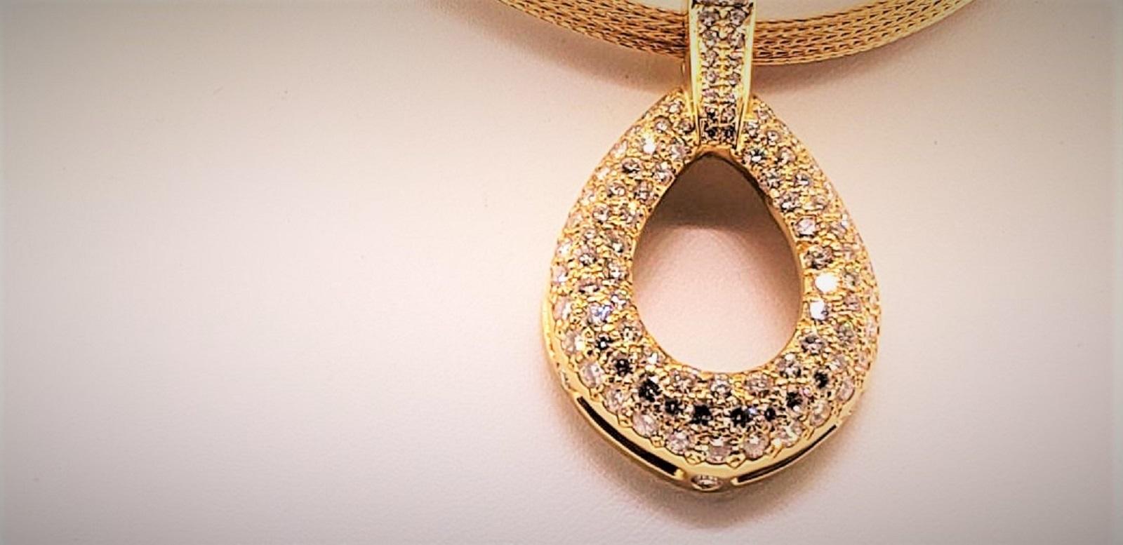 Manufactured in 18K Yellow Gold, this diamond pendant is easy to dress up or down.  The pendant contains 105 diamonds that weigh 5.04 carats and 1 large princess cut diamond 0.60 cts.  Designed by Michael Engelhardt, the pendant rests on an 18 Karat