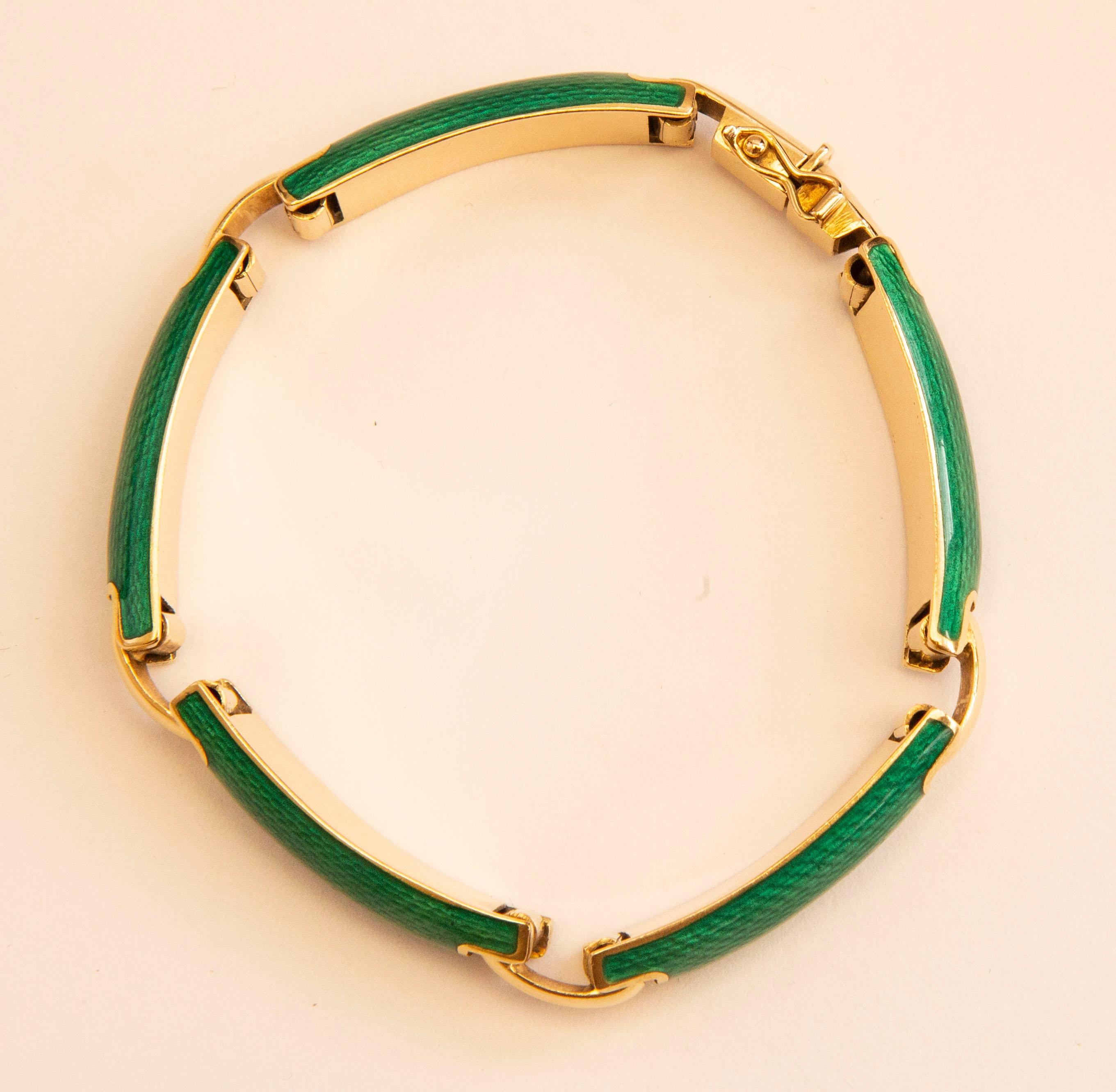 Un bracelet vintage italien en or jaune 18 carats avec des maillons en émail vert vibrant imprimé reptile. Les maillons sont reliés par des barres en forme de demi-lune. Il est doté d'un fermoir et d'une serrure de sécurité pour votre sécurité.
Le