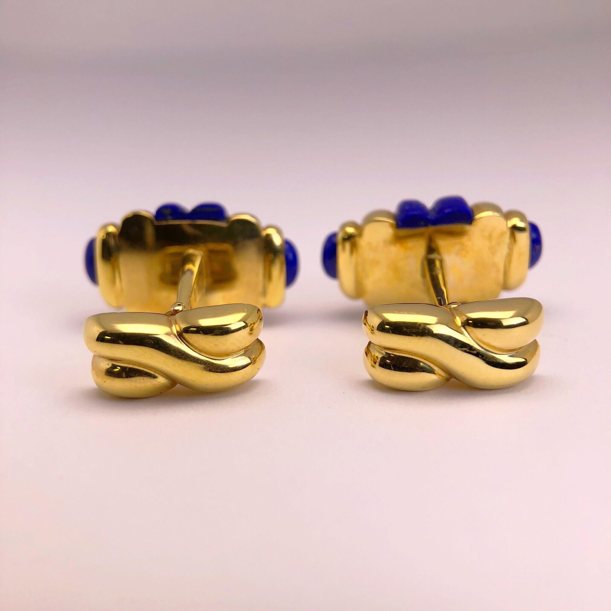 Created by George Gero, renowned worldwide for luxurious men's cuff-links, comes this classic  barrel shaped pair  which are set in 18 karat yellow gold  that alternates with carved Lapis Lazuli.  
Collapsible backs are finished with a criss cross