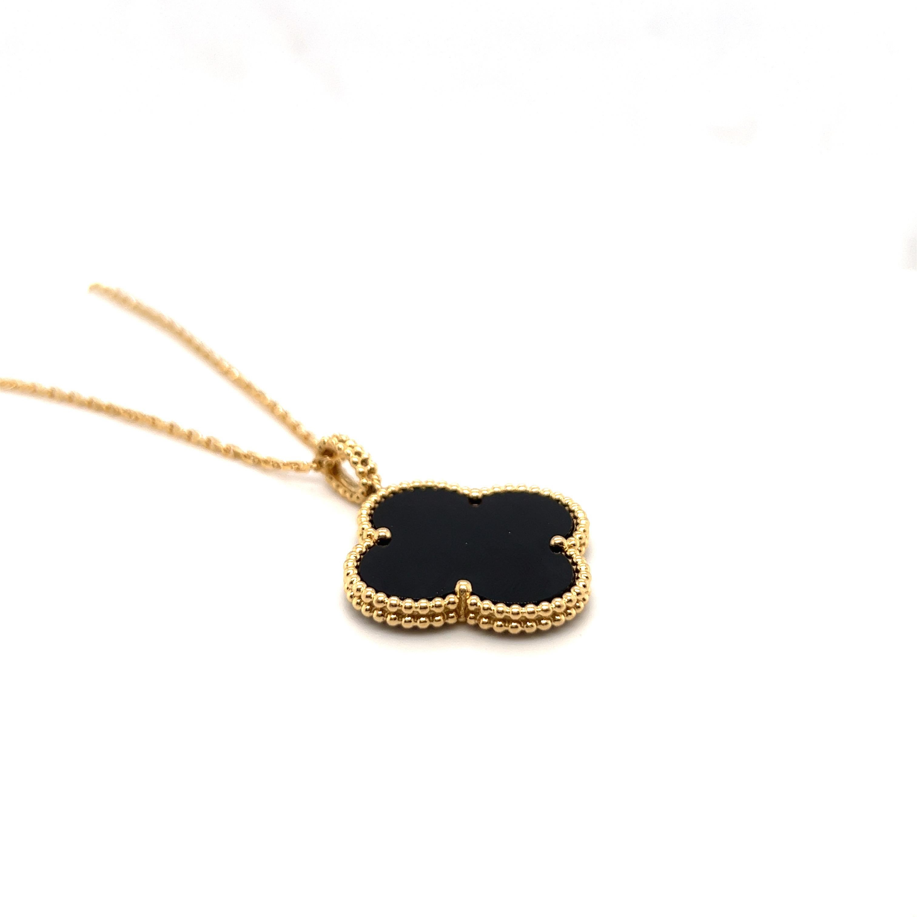Chic Alhambra 18 karat gold and onyx pendant with long chain by renowned jeweller Van Cleef & Arpels. 
This modern classic pendant is designed as a quatrefoil-shaped onyx panel within a beaded gold surround, to an oval bail with gold bead decor.